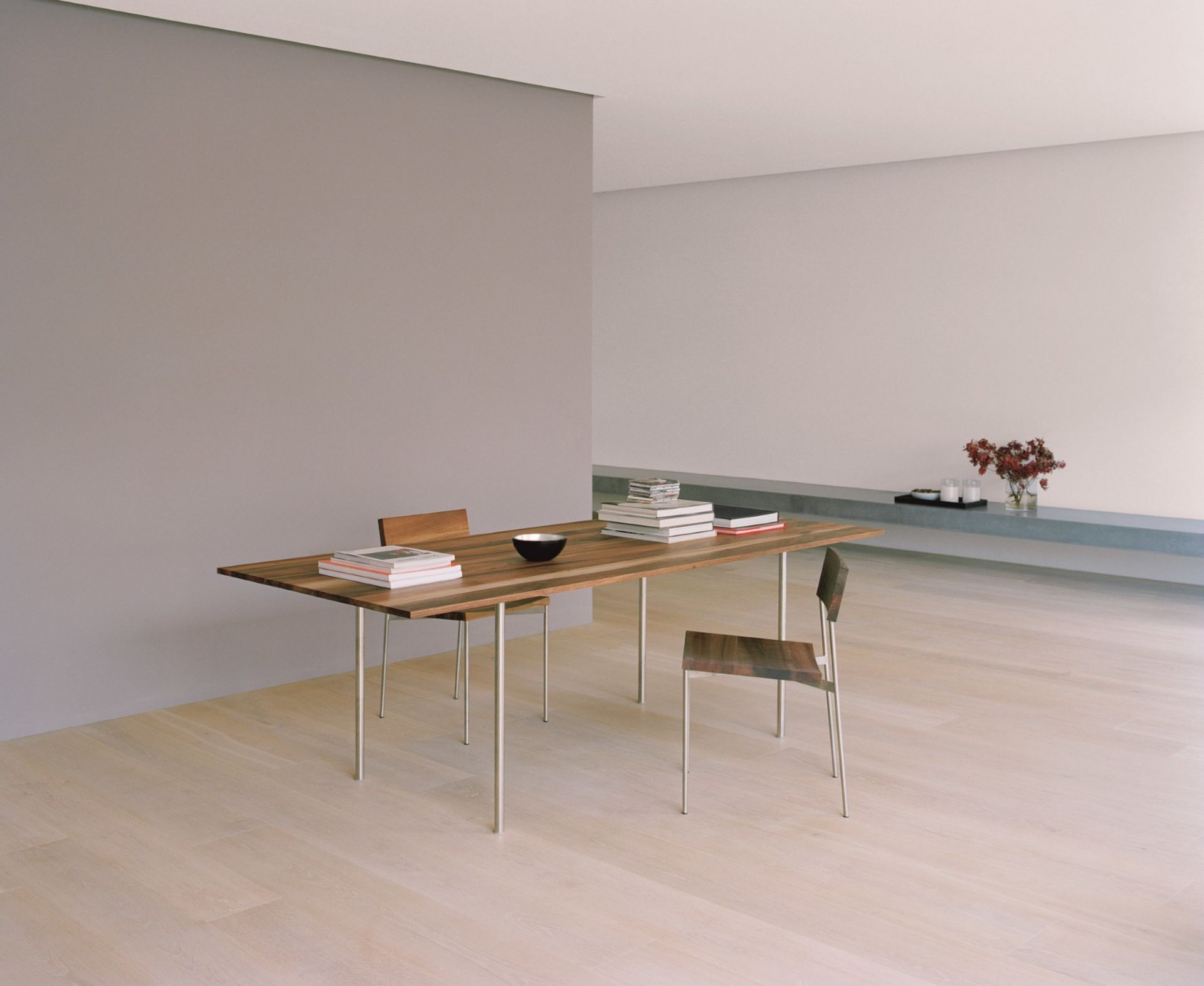 TA14 Anton Tisch von e15 aus Massivholz mit Stahlbeinen und Stühlen im minimalistischen Raum.