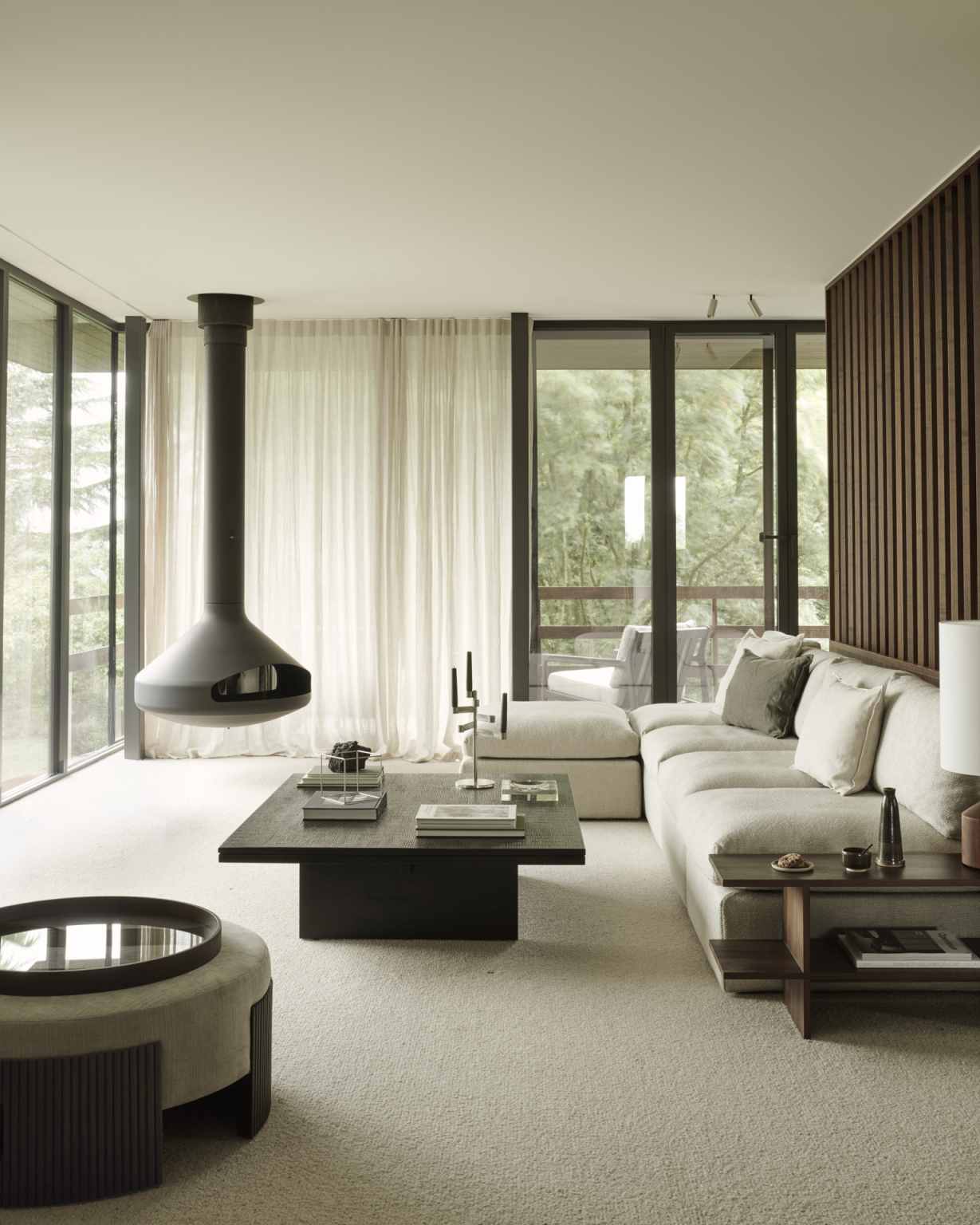 Wohnzimmer mit Ethnicraft Couchtisch "Grooves Coffee Table", Sofa, Kamin und großen Fenstern.