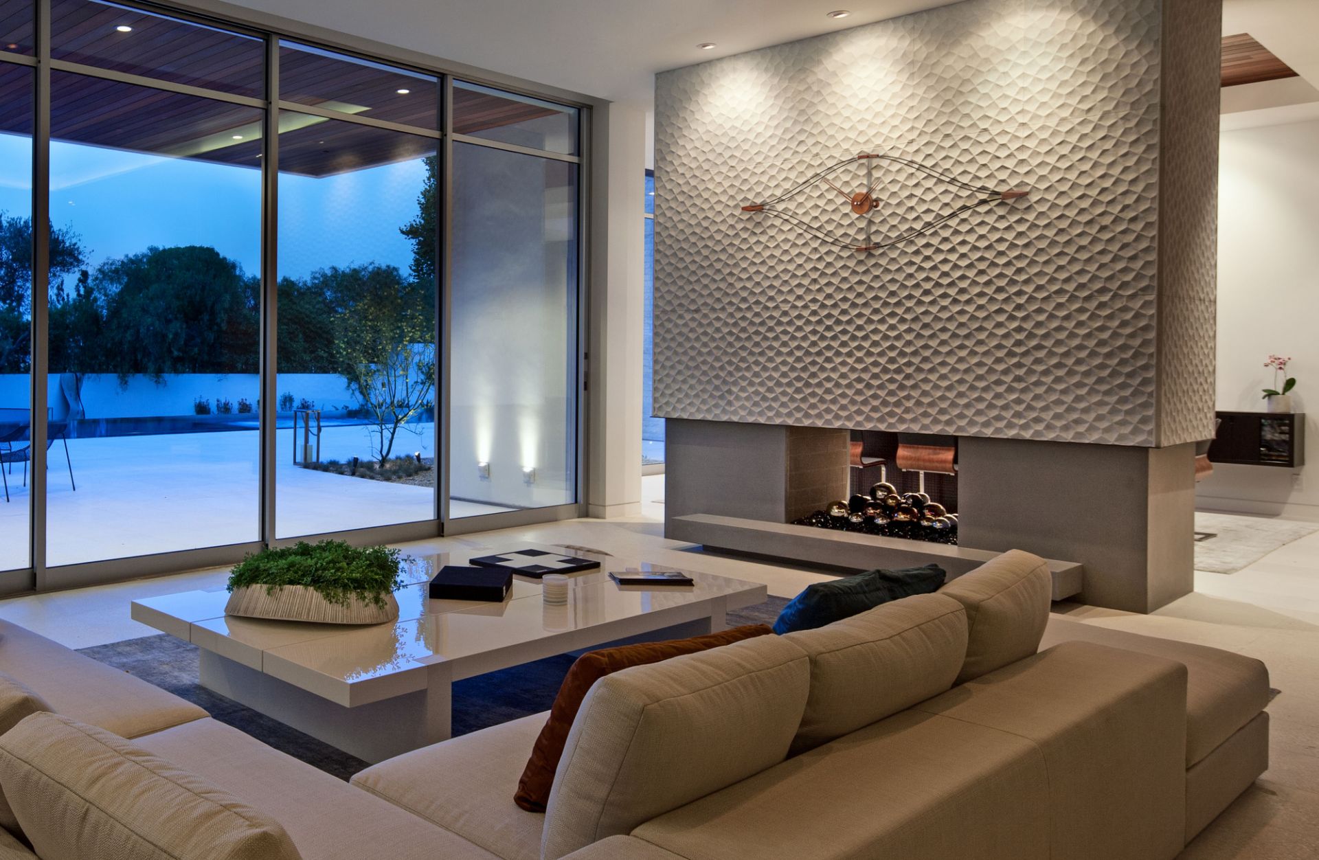 Moderne Wohnzimmergestaltung mit Kamin und einer Look Wanduhr von Nomon als besonderes Designelement.