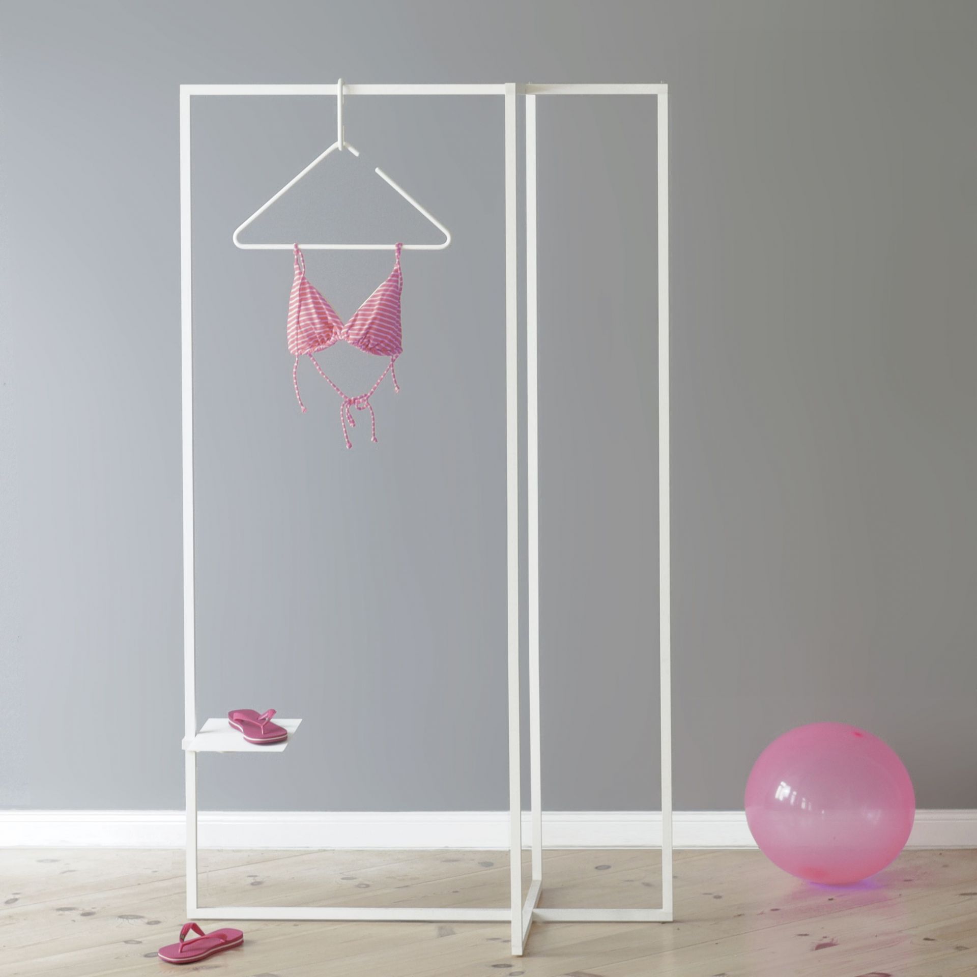 Roomsafari Modular Frames L Garderobe in Weiß mit Bikini, Sandalen und pinkem Ballon.