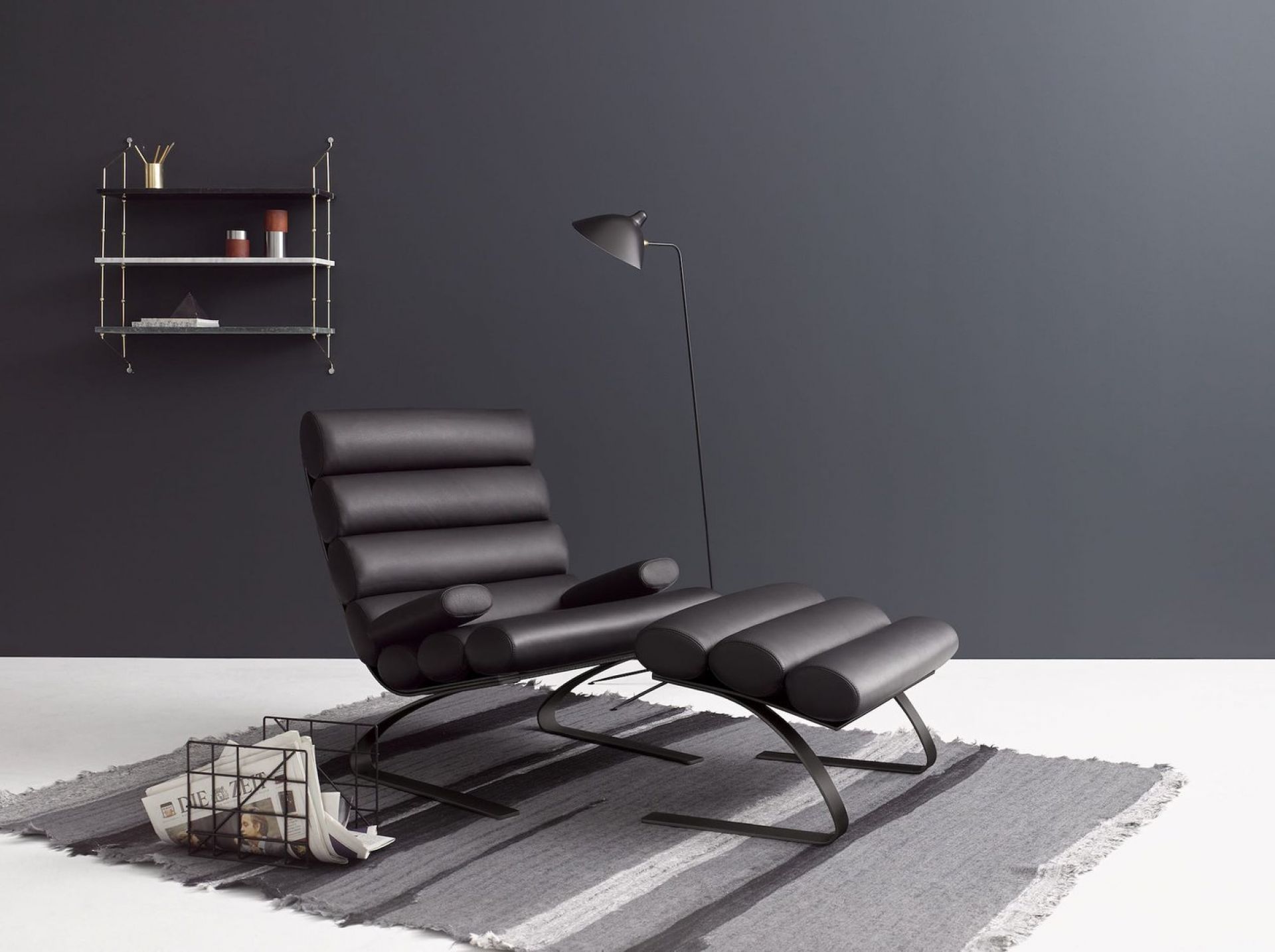 Schwarzer Cor Hocker aus Leder mit Fußhocker auf grauem Teppich, modernes Möbeldesign für Wohnzimmer.