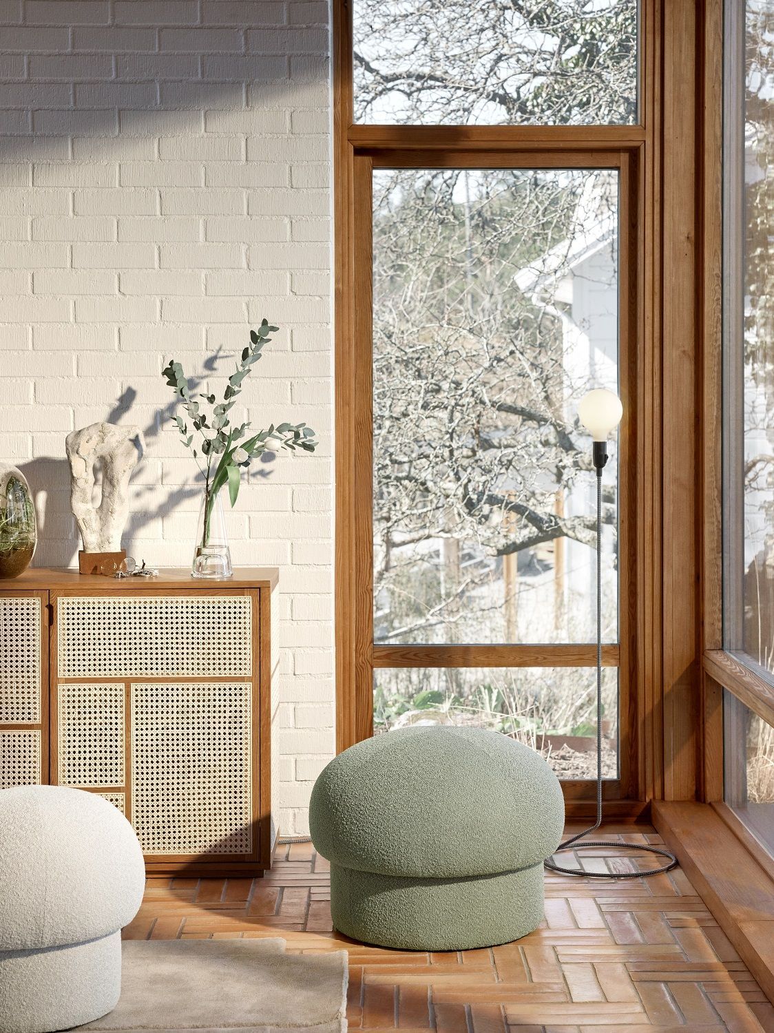 Nahaufnahme eines grünen Uno Pouf Hockers von Design House Stockholm in einem hellen Wohnraum.