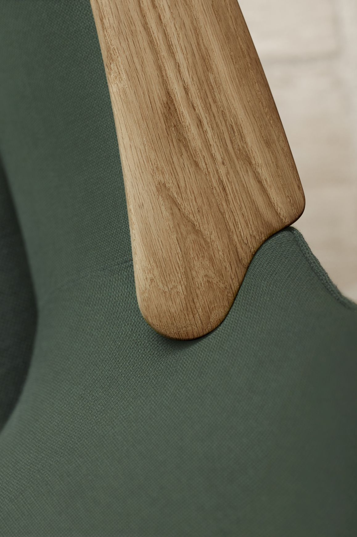Detailaufnahme: CH78 Mama Bear Sessel von Carl Hansen & Søn, braunes Holz, grüner Stoff.