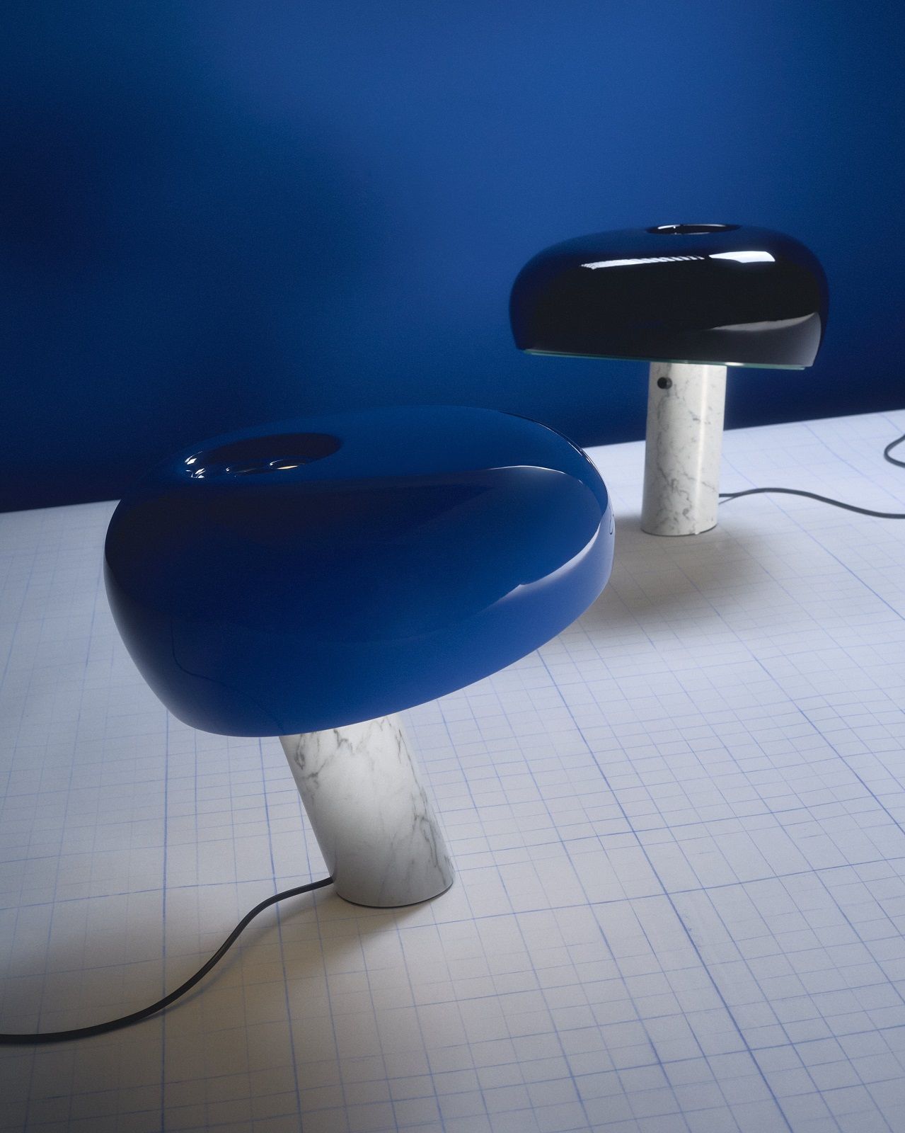 Blaue und schwarze Snoopy Tischleuchten von Flos mit Marmorfuß auf einem Tisch.