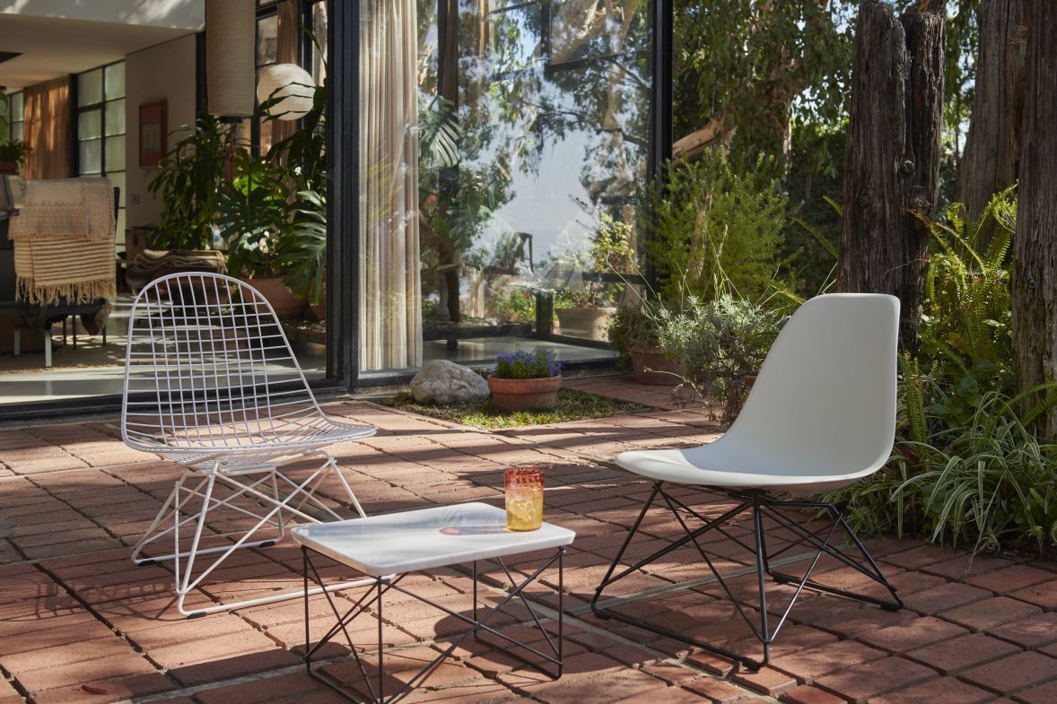 Eames Fiberglass Chair LSR Stuhl von Vitra im Garten, mit Tisch und Drahtstuhl.