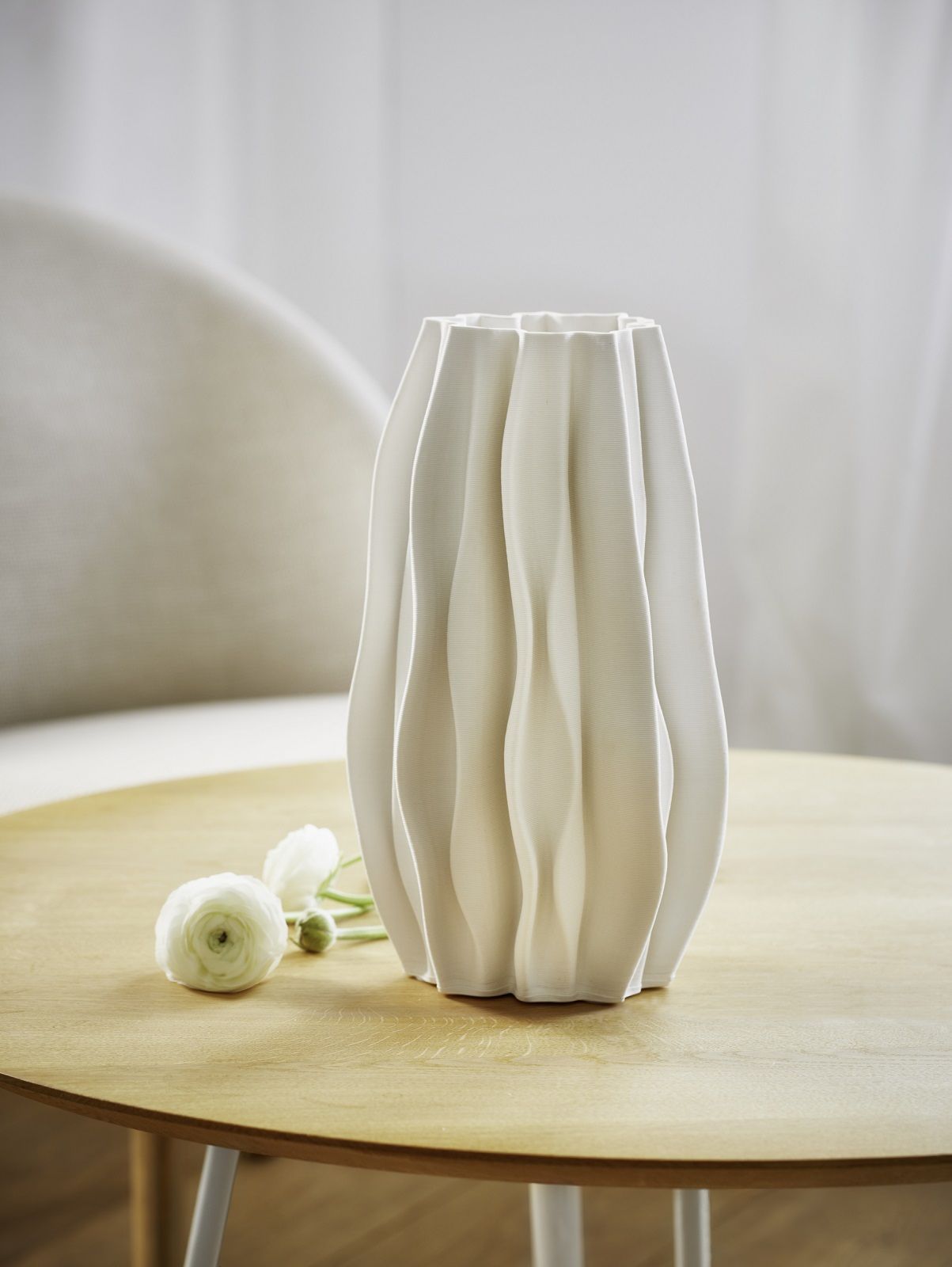 Weiße PLISSEE Vase von Philippi aus Keramik mit Blumen auf einem Holztisch.