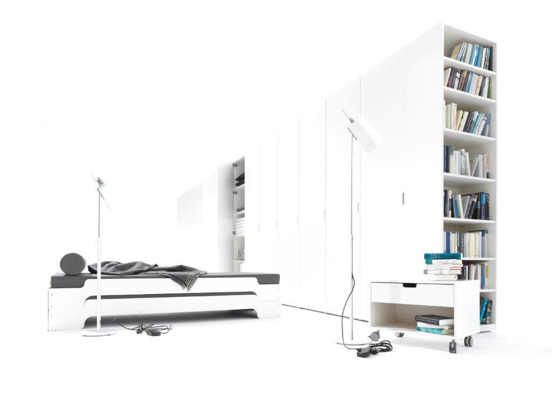 Weißer Müller Möbelwerkstätten Nachttisch mit Schublade und Rollen neben Bücherregal und Stapelliege.