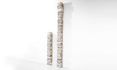 Ptolomeo Wall Büchersäule von Opinion Ciatti: Zwei vertikale Bücherstapel an einer weißen Wand.