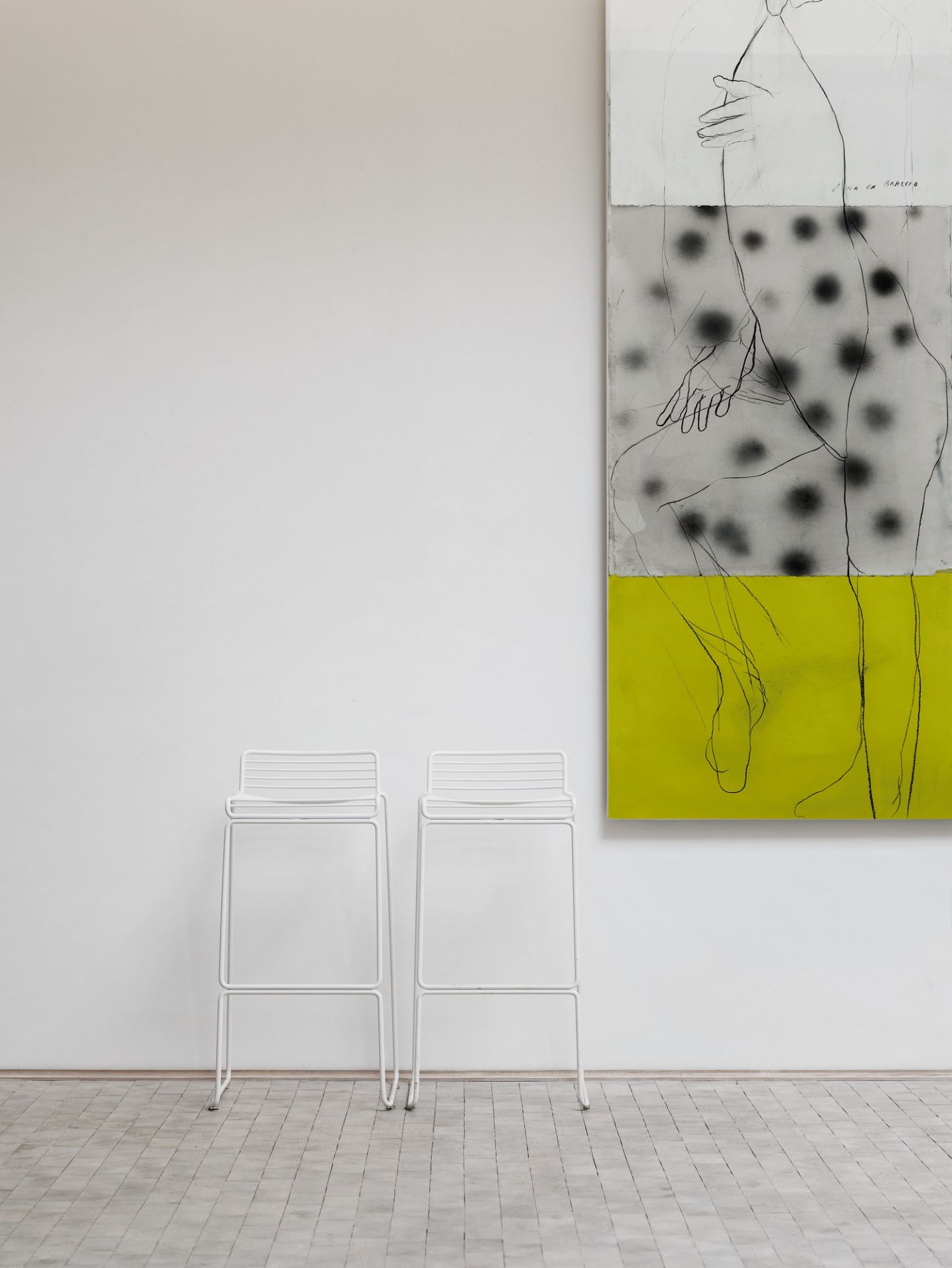 Zwei weiße Hee Barhocker von Hay vor einer weißen Wand mit Kunstwerk.