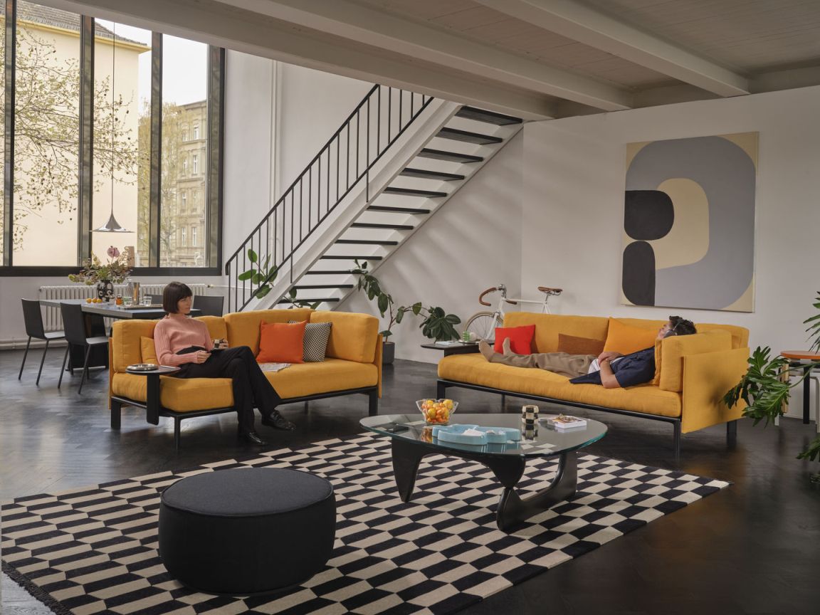 Wohnzimmer mit gelbem Sofa und Anagram Rückenkissen von Vitra, 110 cm breit.