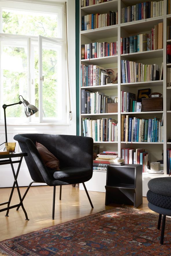 Schwarzer Mono Tritthocker von Richard Lampert im Wohnzimmer mit Sessel und Bücherregal.