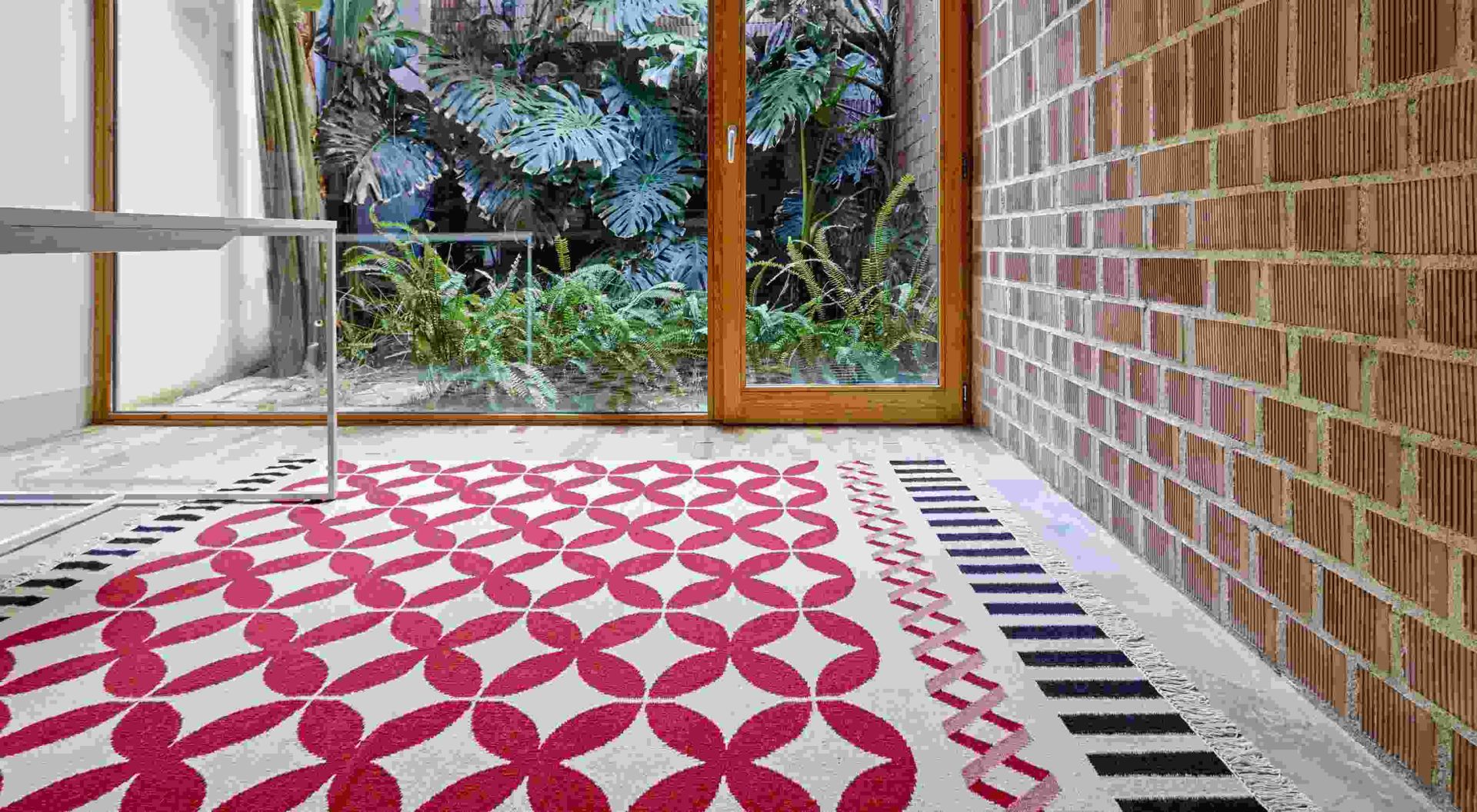 Kilim Catania Teppich mit rotem Blütenmuster und dekorativen Bordüren im modernen Raum.