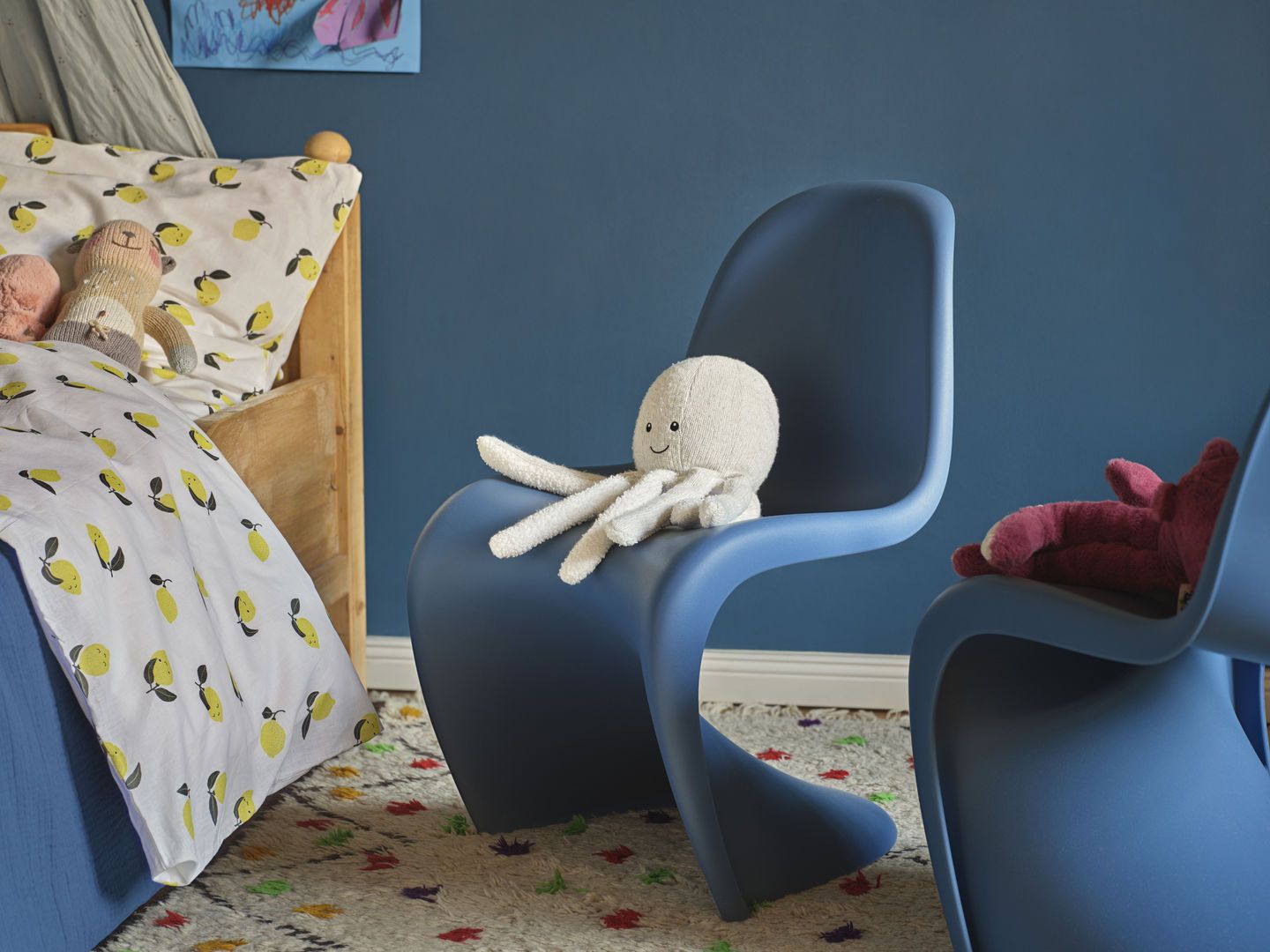 Blauer Panton Junior Stuhl von Vitra im Kinderzimmer mit Spielzeug darauf. Kinderstuhl Design.