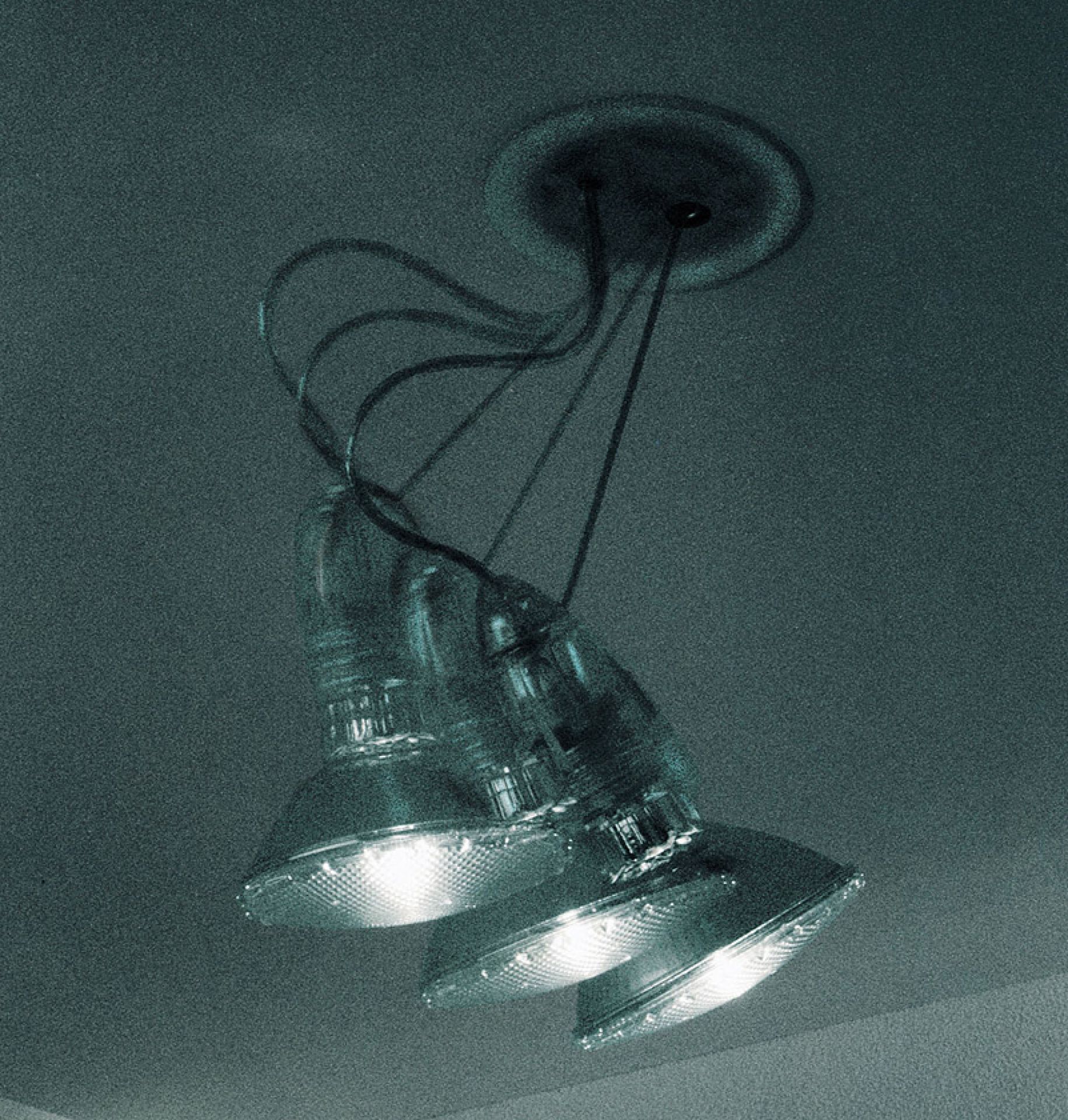 Nahaufnahme der Spock Deckenleuchte von Ingo Maurer mit drei strahlenden Lampen.