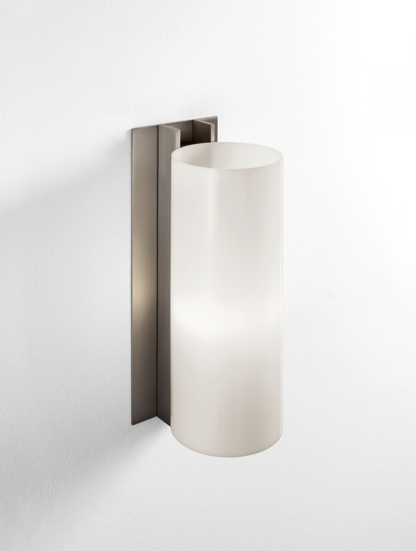 TMM Metálico Wandleuchte von Santa & Cole mit zylindrischem Lampenschirm und Metallhalterung an weißer Wand.