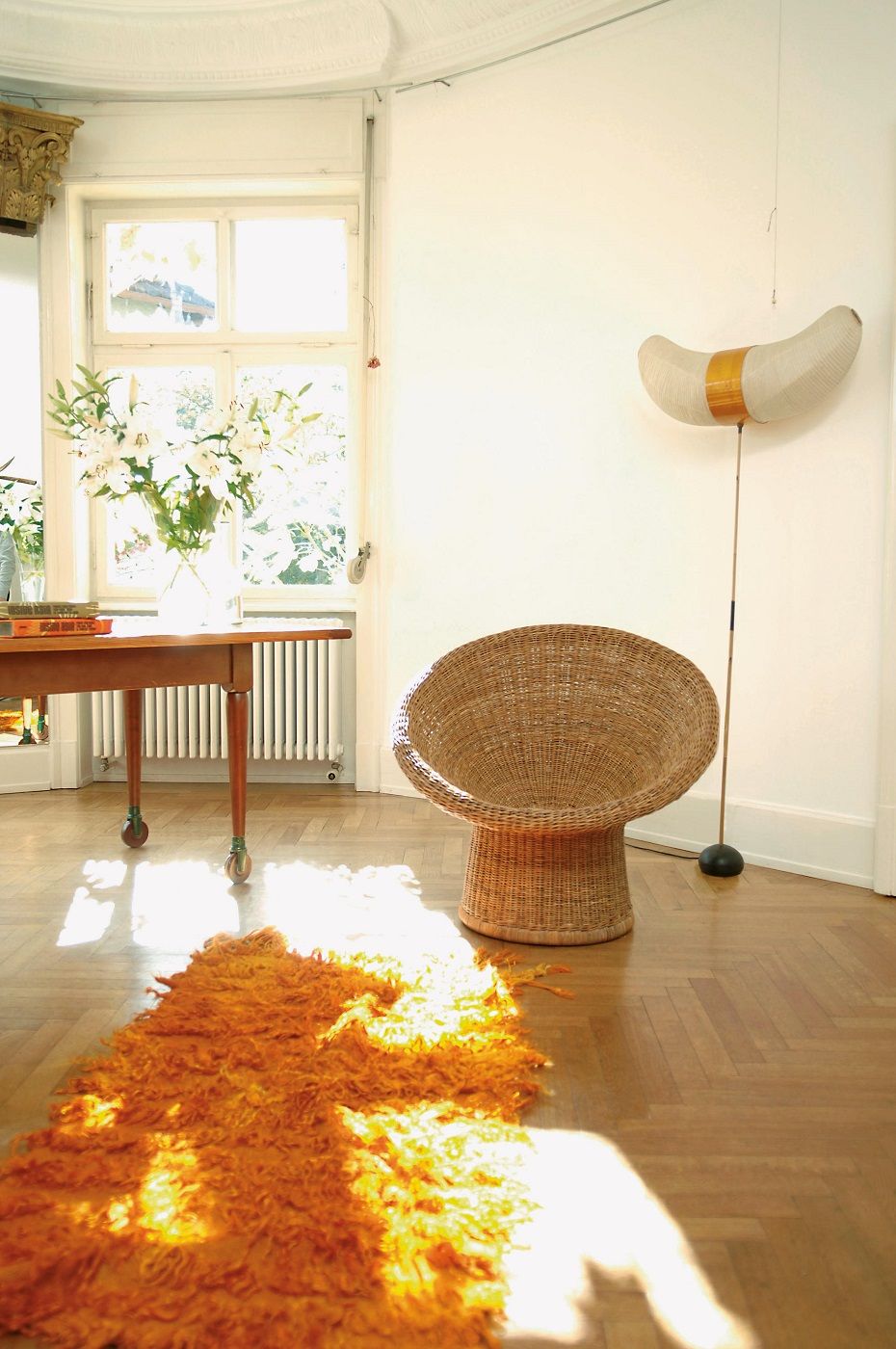 E 10 Rattansessel von Richard Lampert in hellem Raum mit Teppich und Tageslicht.