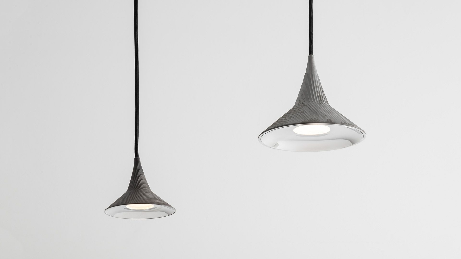 Zwei graue Unterlinden Kronleuchter von Artemide mit Aluminium-Lampenschirm und warmweißem 3000K Licht.