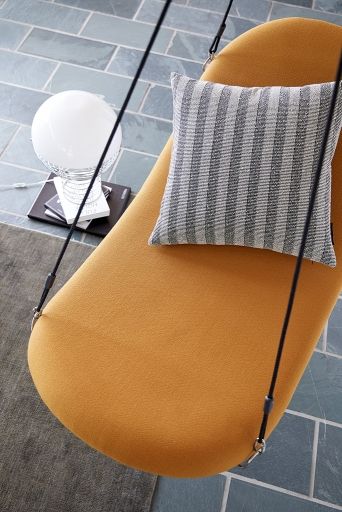 Gelber Flying Chair Schaukelsessel mit gestreiftem Kissen, hängend. Gemütlicher Sessel für entspannte Momente.