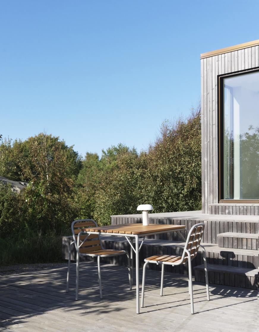 Normann Copenhagen Vig Table 90x90 cm Outdoor Tisch mit zwei Stühlen auf Holzterrasse.