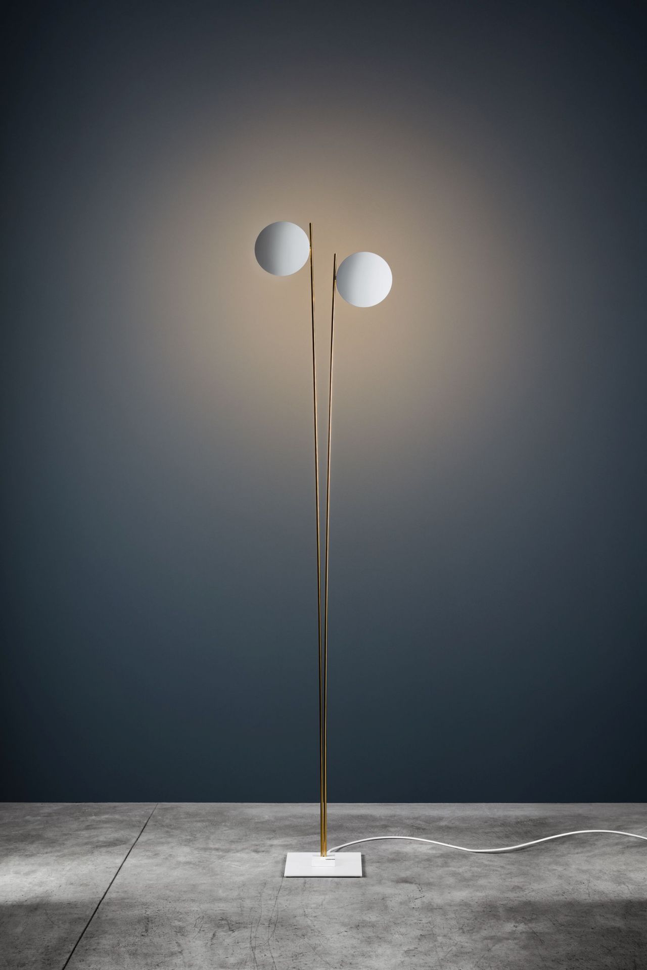 Lederam F2 Stehleuchte von Catellani & Smith mit zwei runden, leuchtenden Schirmen.