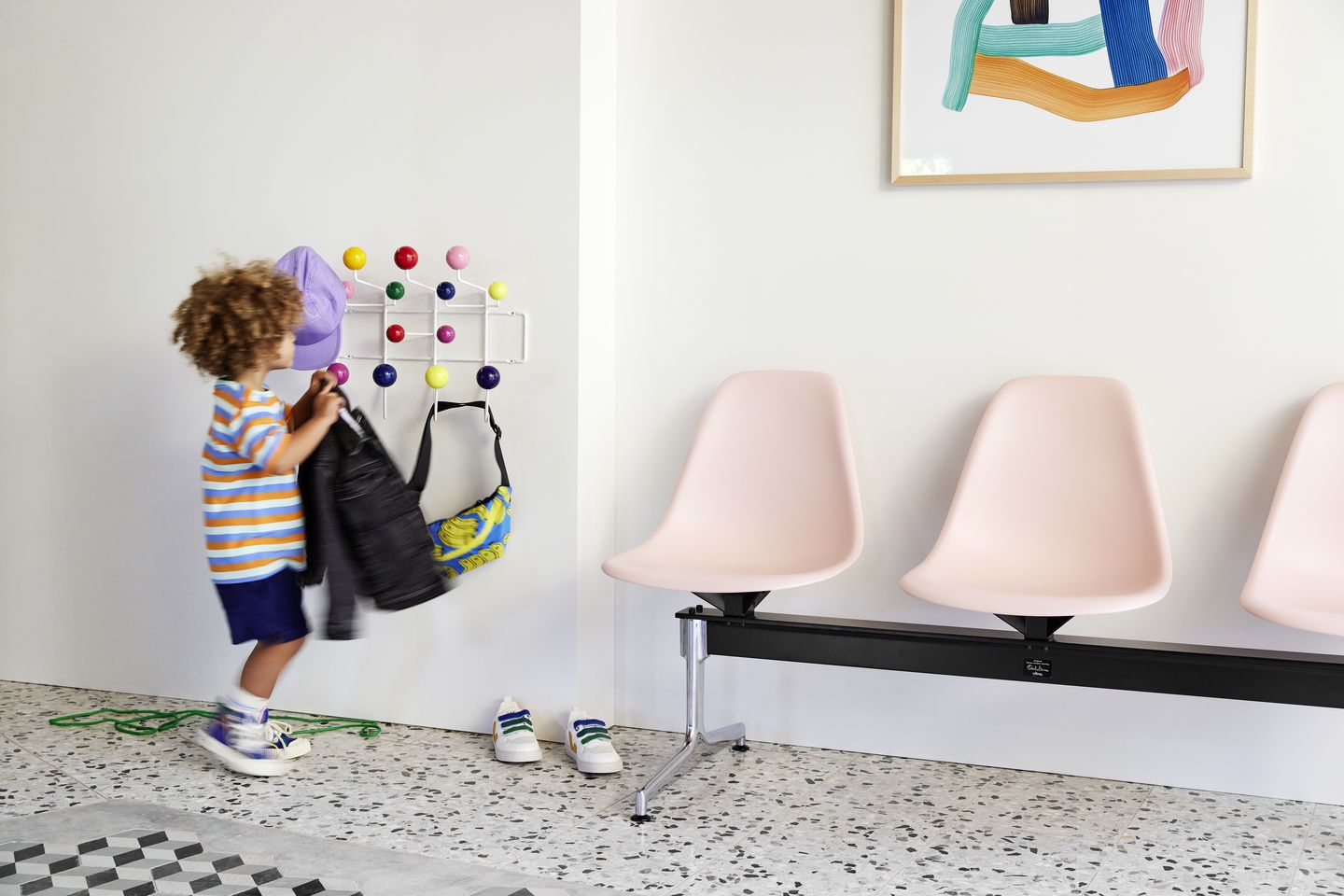 Eames Plastic Side Chair auf Traverse von Vitra in Rosa, Wartebereich mit Kind.