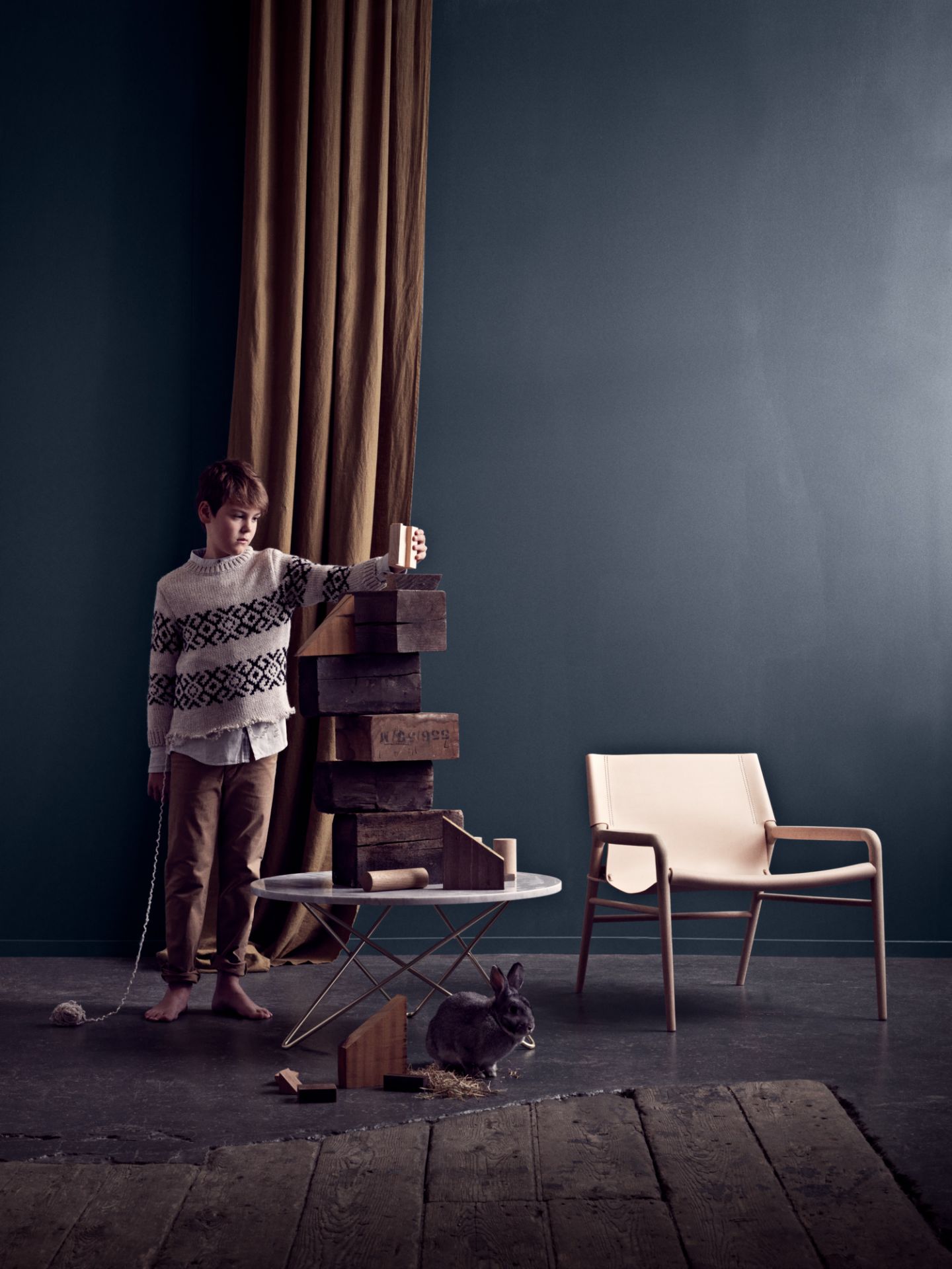 Rama Sessel von Ox Denmarq: Cognacfarbener Ledersessel im modernen Wohnzimmer mit Kind und Kaninchen.