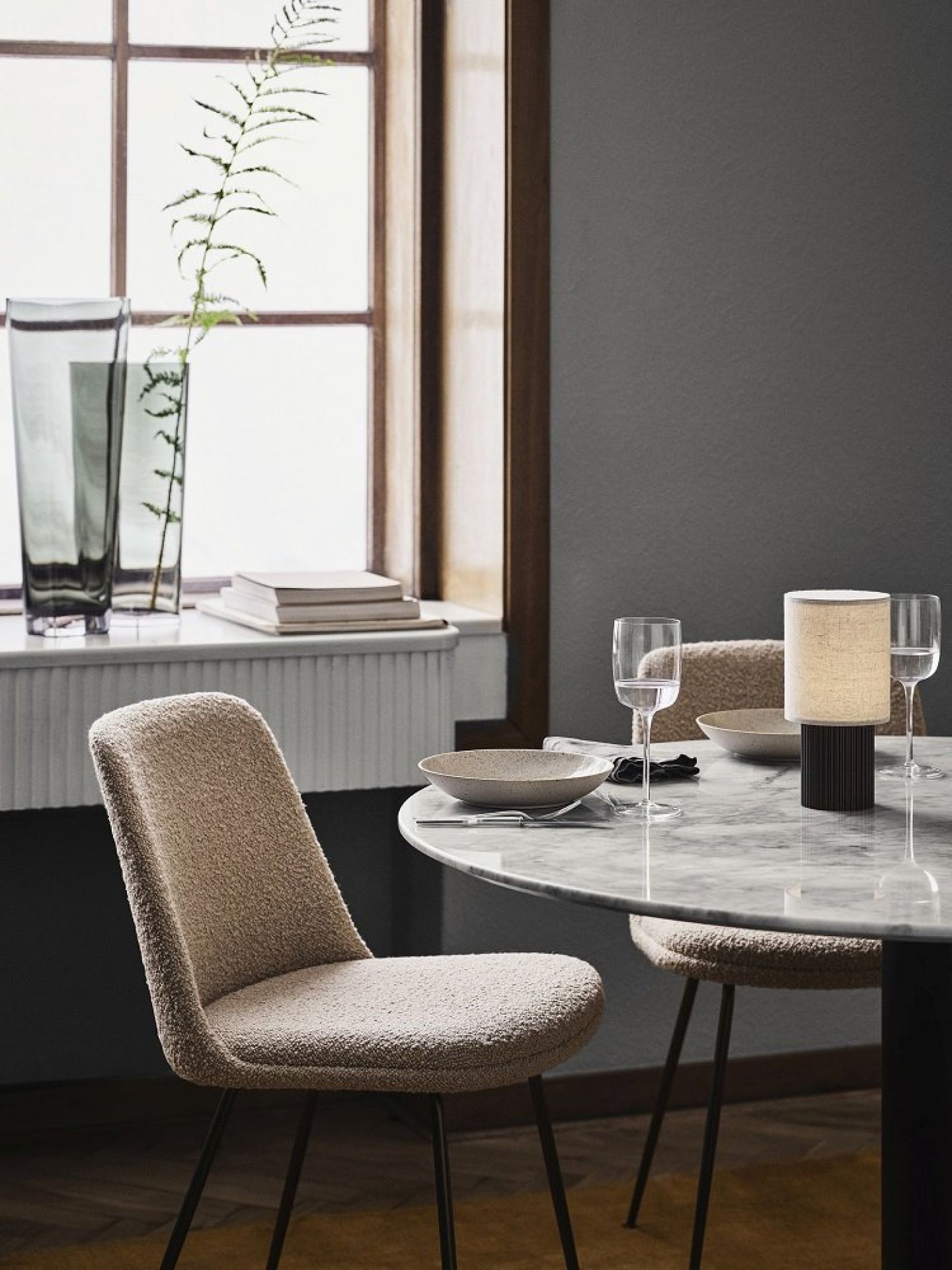 Manhattan SC52 Tischleuchte von AndTradition auf einem Esstisch mit Stühlen und Geschirr.