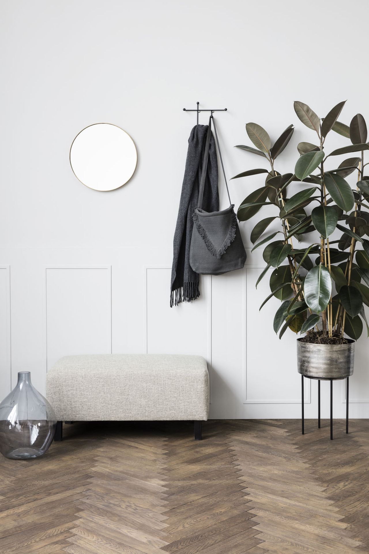 Schwarzer Prea Wandhaken von House Doctor mit Schal und Tasche an weißer Wand.