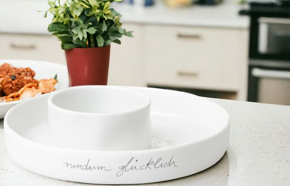 Weiße Servierschale mit Dip-Schale und Aufschrift "rundum glücklich", ideal für Snacks und Dips.