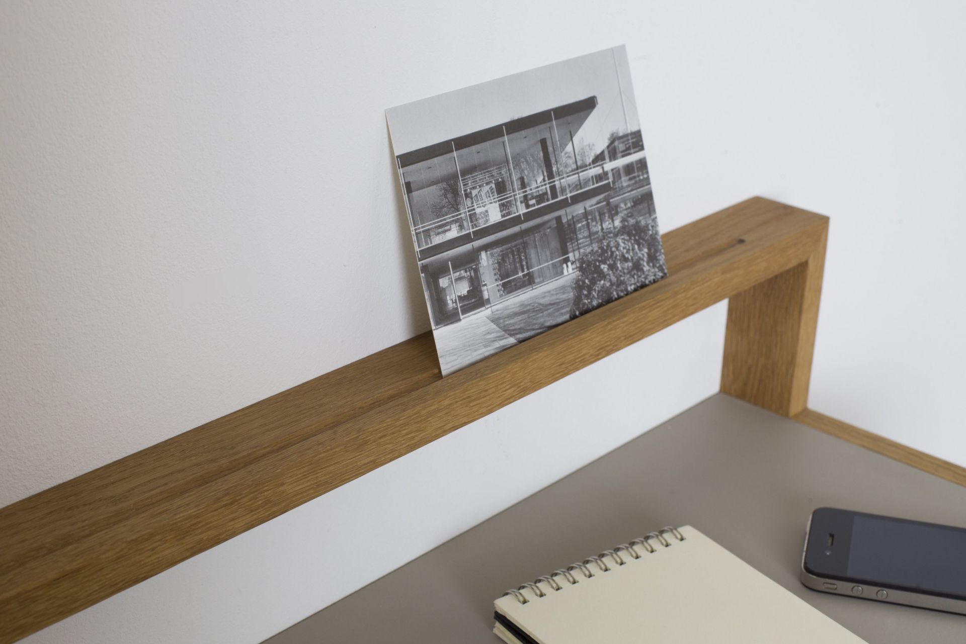 Hellgraues Ablageboard "buck1" von das kleine b mit Foto, Notizblock und Smartphone.
