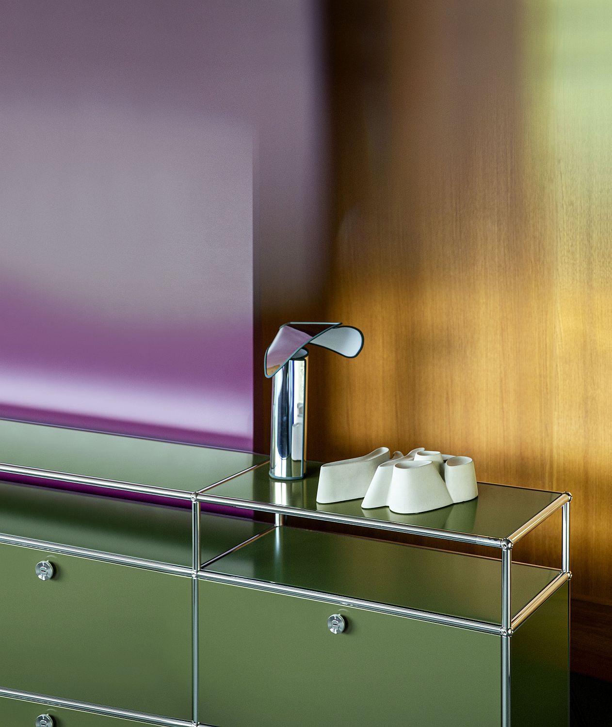 Nahaufnahme eines grünen USM Haller Sideboards mit Lampe und Deko-Objekten auf der Oberfläche.