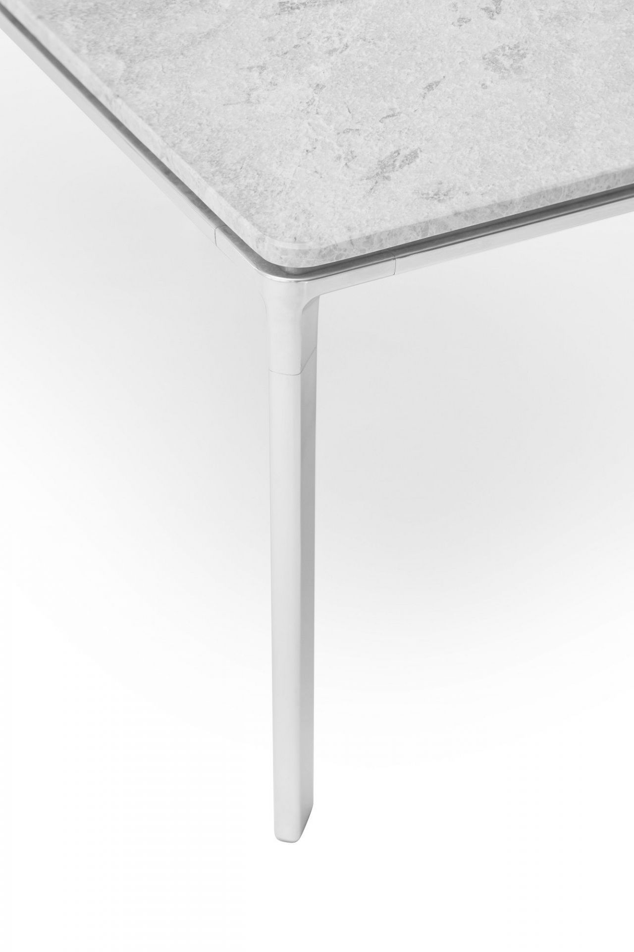 Detailaufnahme: Vipp Couchtisch mit grauer Marmorplatte und weißem Metallgestell. Moderner Wohnzimmertisch.