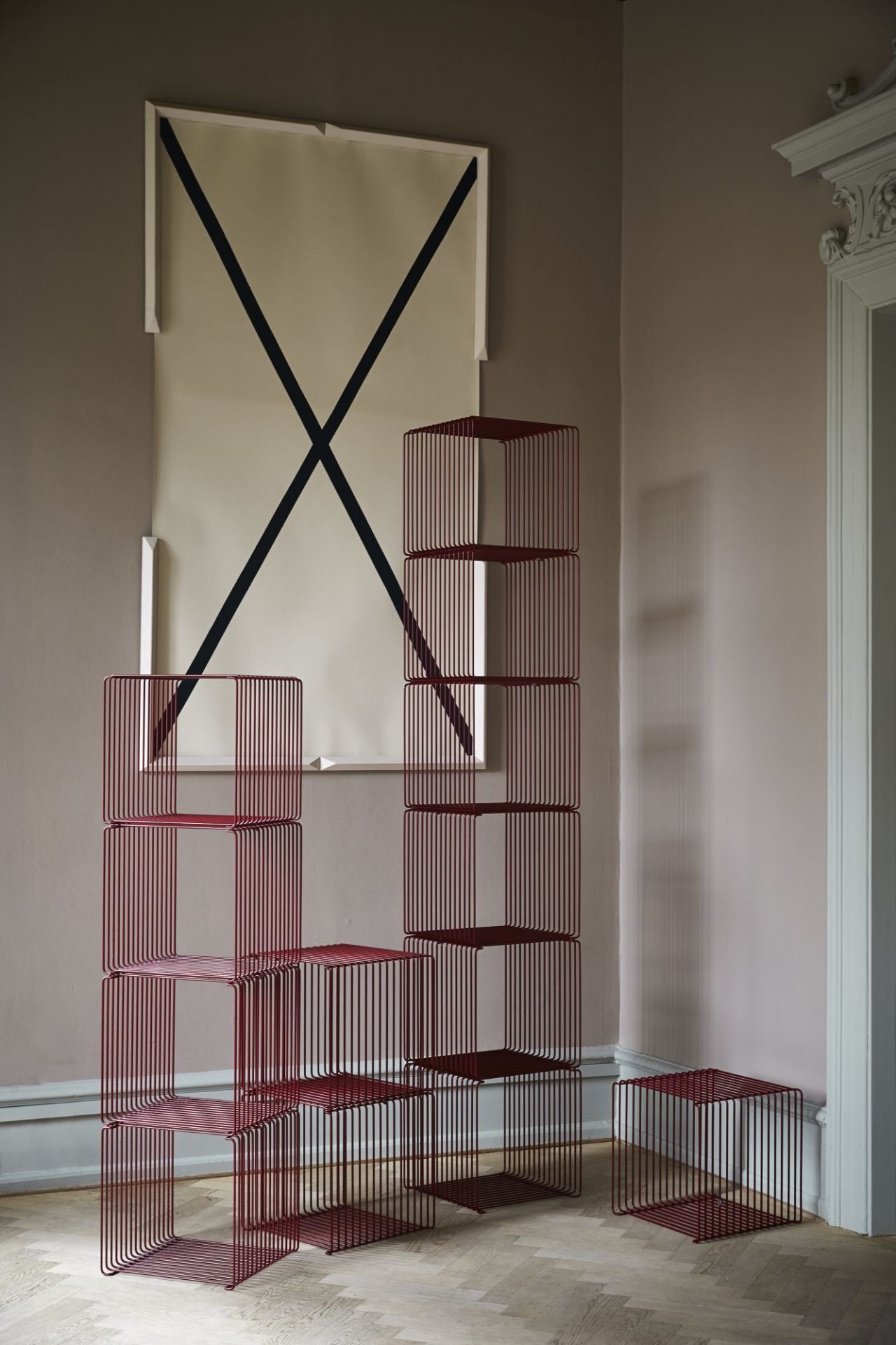 Burgunderrotes Montana Wire Cube Regal, bestehend aus mehreren Würfeln, gestapelt im modernen Wohnraum.