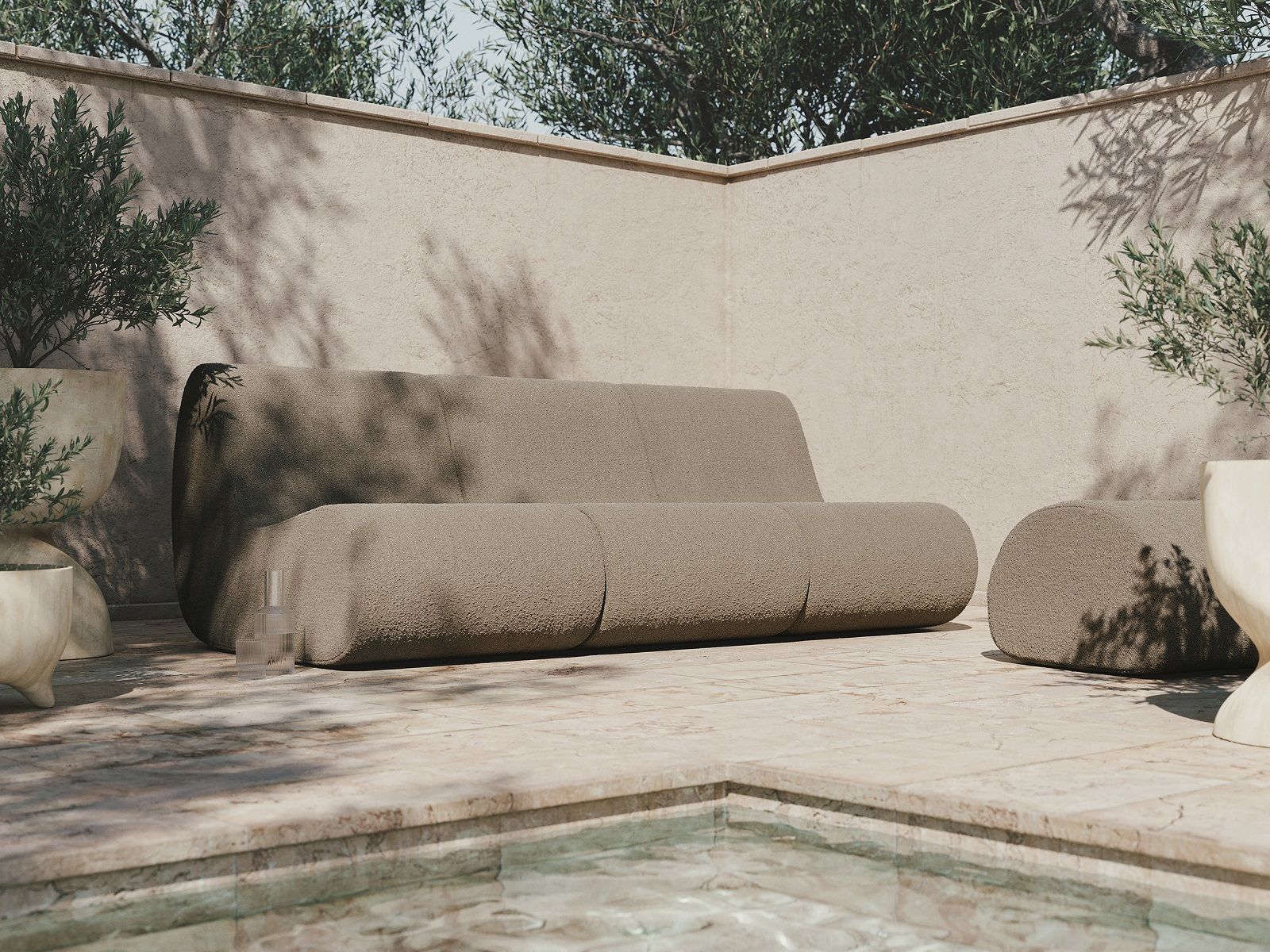 Ferm Living Rouli Modulsofa aus Bouclé in Dunkelsand für den Außenbereich, nah am Pool.