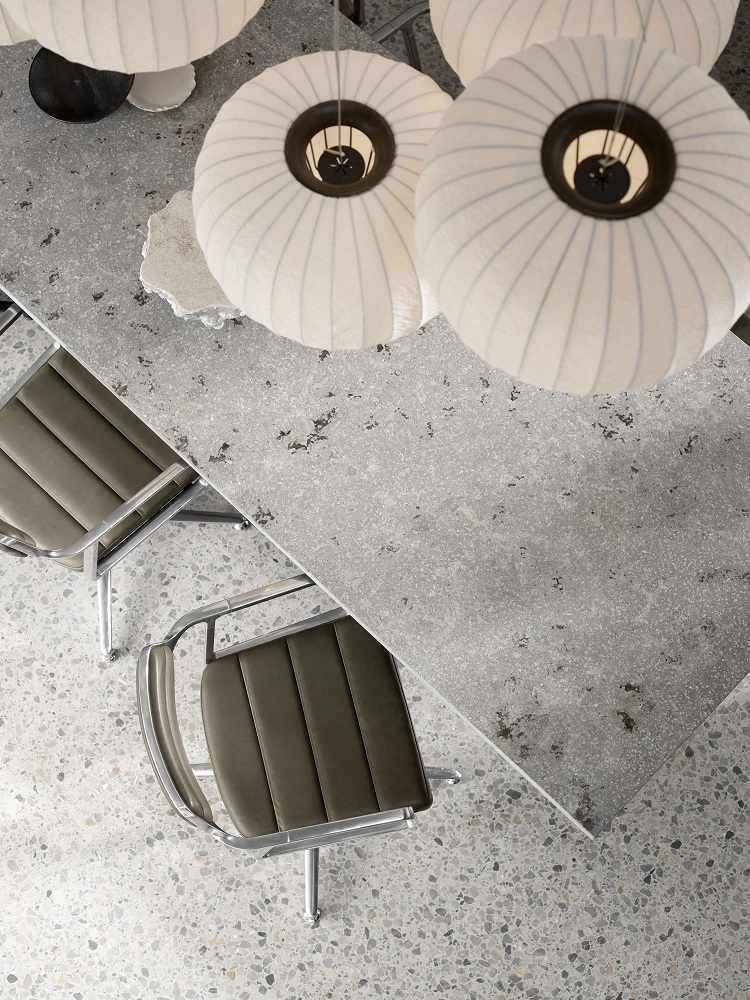 Draufsicht: Vipp Cabin Square Table Esstisch mit Stühlen und Pendelleuchten in grauem Interieur.