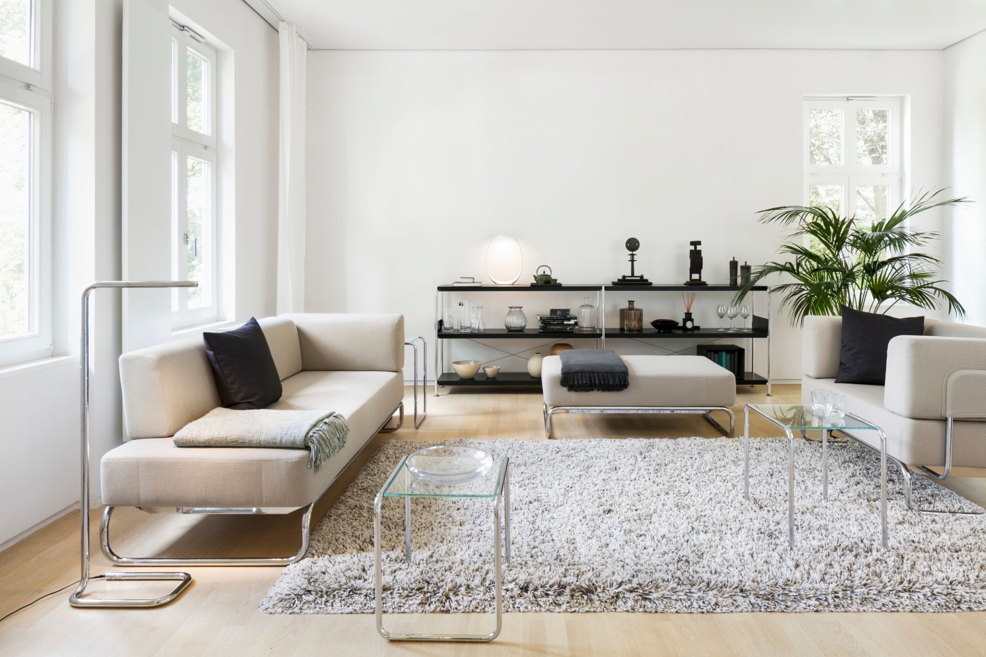 Heller Wohnraum mit Thonet Sessel, Sofa, Couchtisch und Regal im modernen Design.