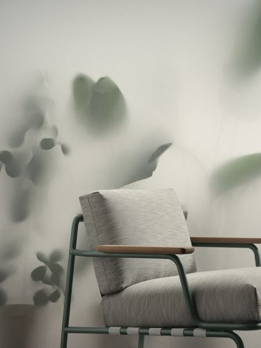 Nahaufnahme des Muuto Settle Lounge Chair Outdoor Sessels mit grauem Bezug und grünen Rahmen.