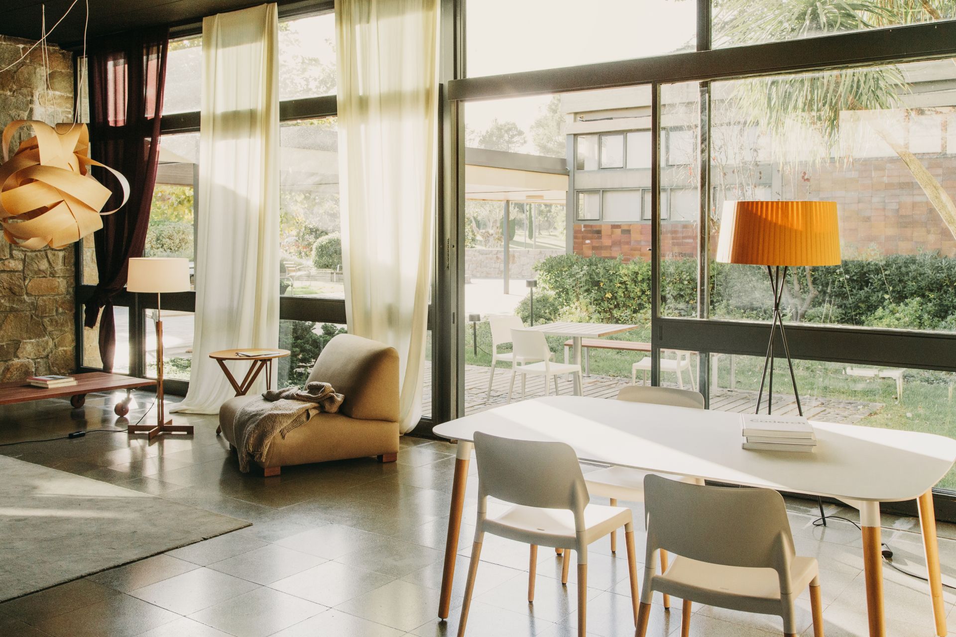 Heller Raum mit Belloch Esstisch von Santa & Cole, weißen Stühlen und großem Fenster.