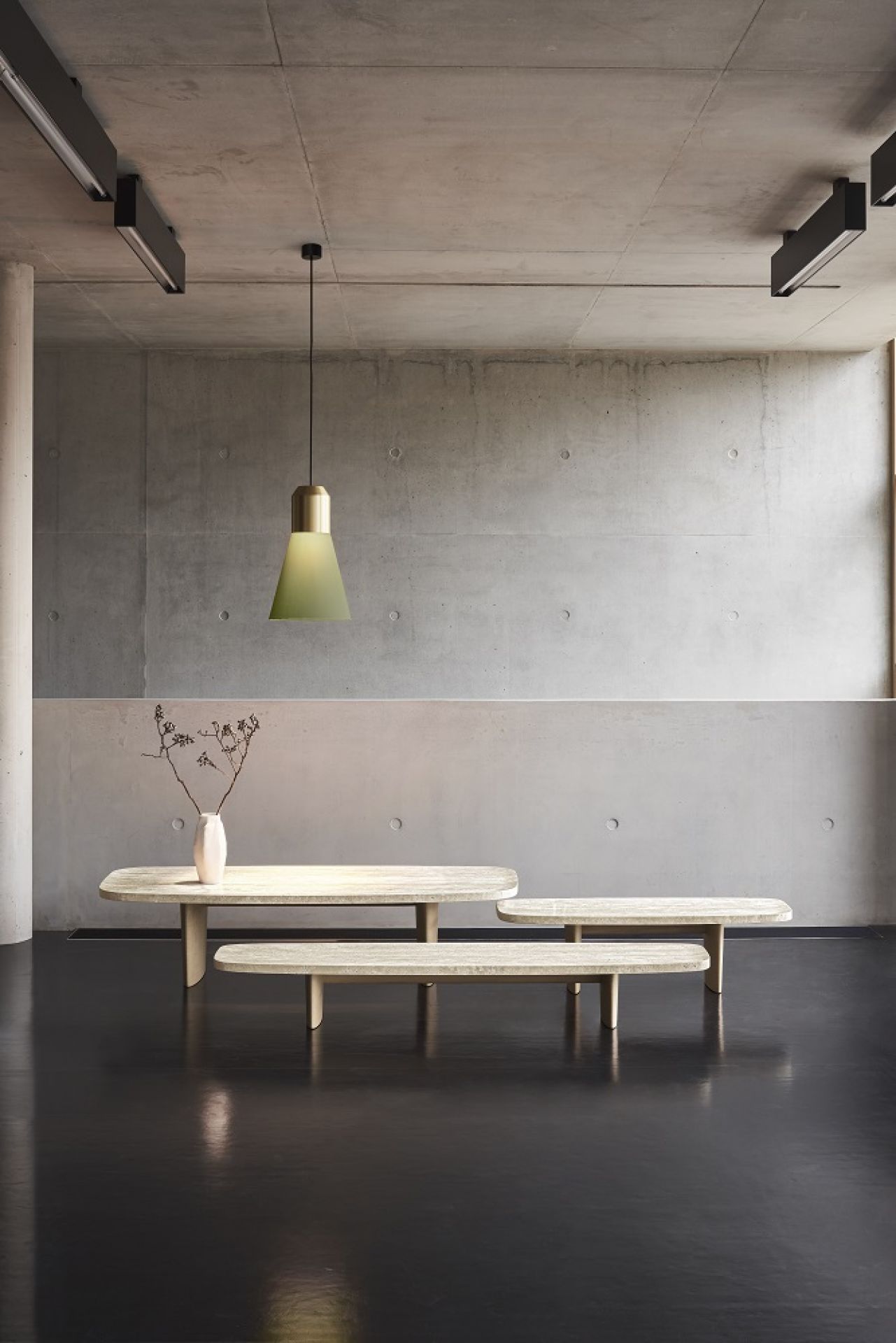 Classicon Beistelltisch Matéria Side Table aus Travertin, mit Vase und Lampe in minimalistischem Interieur.