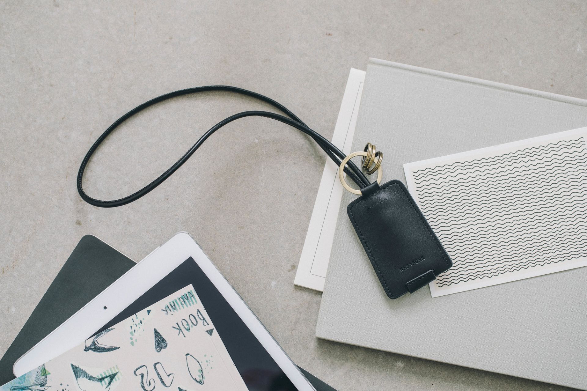 cCHAIN Schlüsselanhänger von Kreafunk mit USB-Kabel, schwarzes Leder, goldene Ringe, modernes Accessoire für unterwegs.