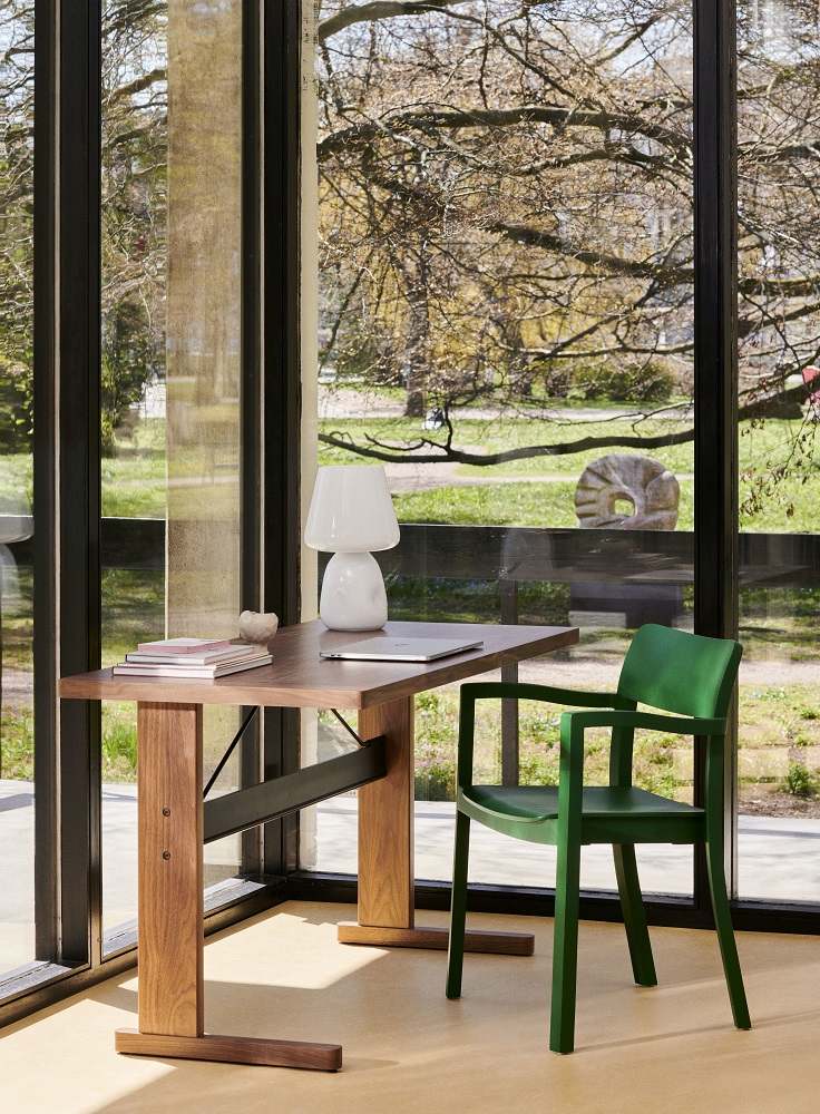 Grüner Pastis Armchair Armlehnenstuhl von Hay an einem Schreibtisch vor einem Fenster.