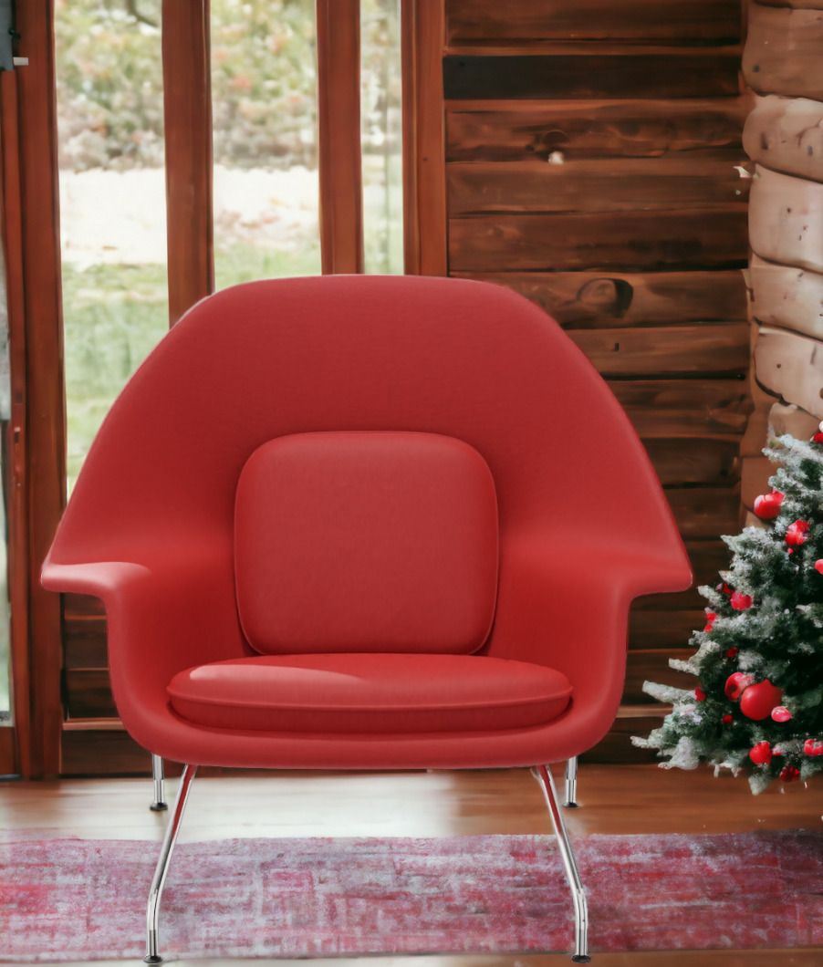 Roter Womb Chair Sessel von Knoll International mit Chromgestell vor rustikalem Holzhintergrund.