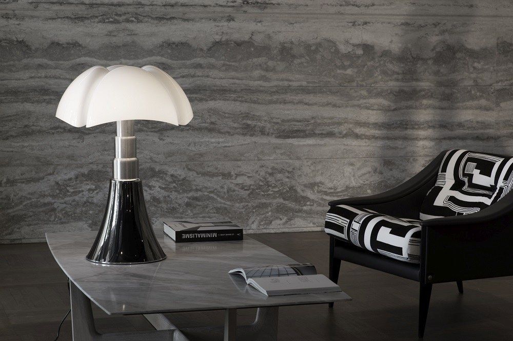 Pipistrello Tischleuchte von Martinelli Luce mit weißem Lampenschirm und schwarzem Fuß auf Tisch.