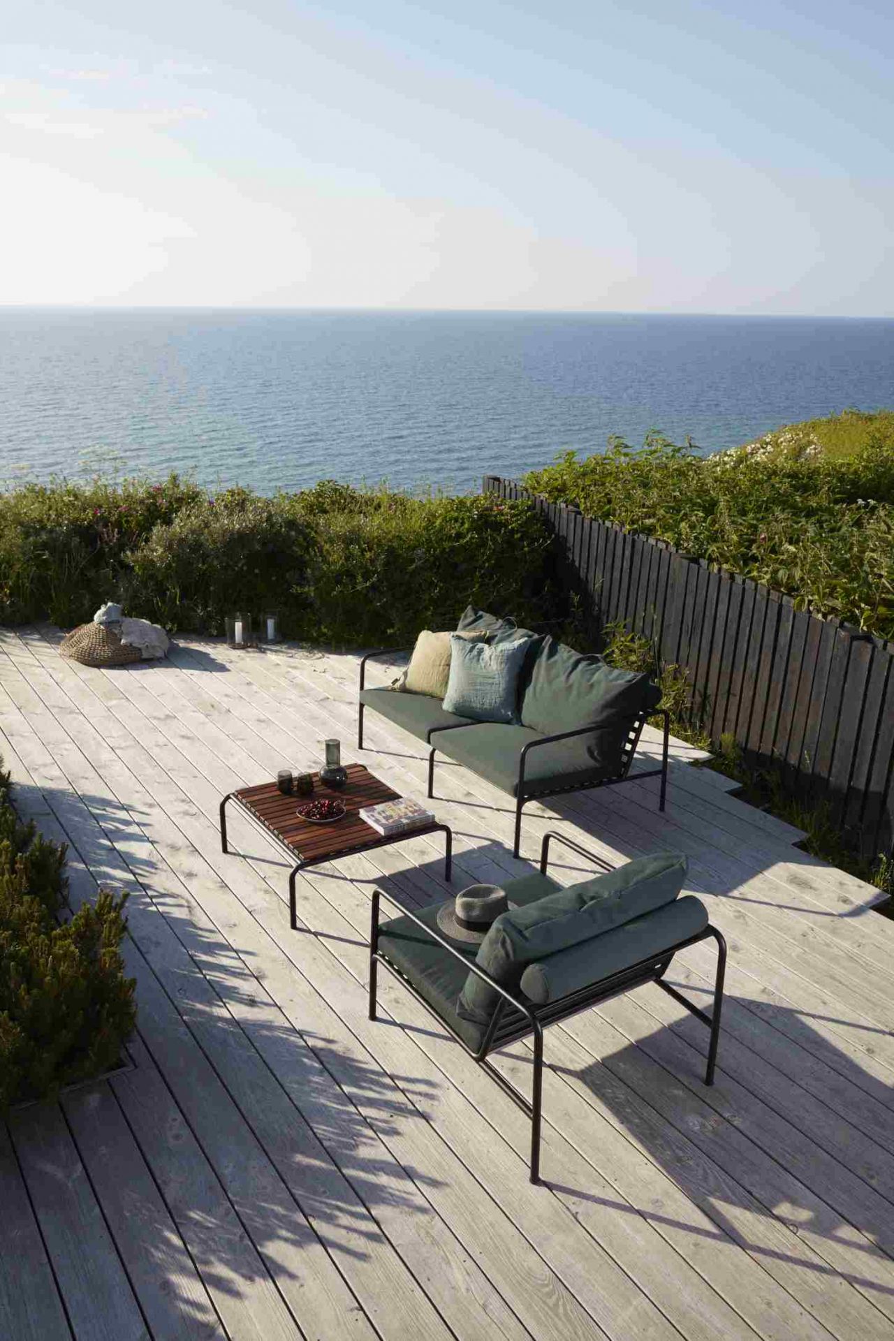 Avon Lounge Chair Outdoor Sessel Houe auf Holzterrasse mit Meerblick, moderne Gartenmöbel.