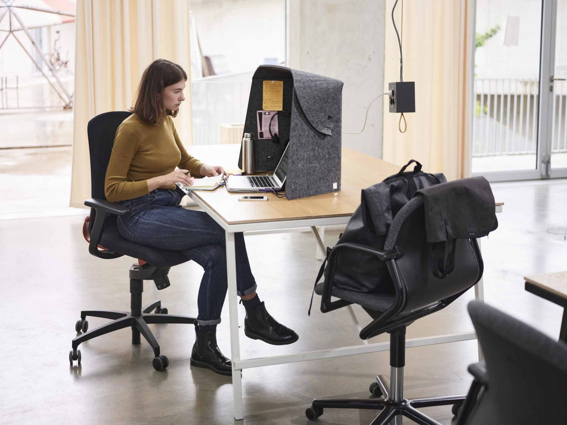 Frau arbeitet am Laptop im Wilkhahn Fold-Up-Workspace, einem mobilen, akustischen Arbeitsplatz.