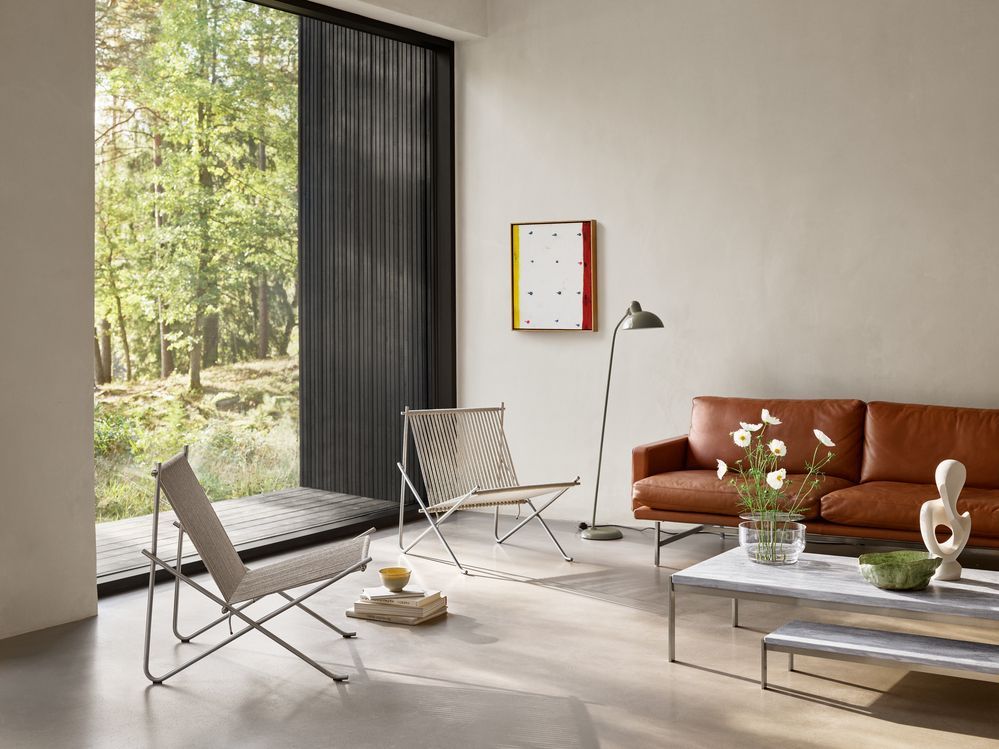 Wohnzimmer mit PK4 Lounge Chair von Fritz Hansen, Sessel aus Edelstahl und Naturmaterialien.