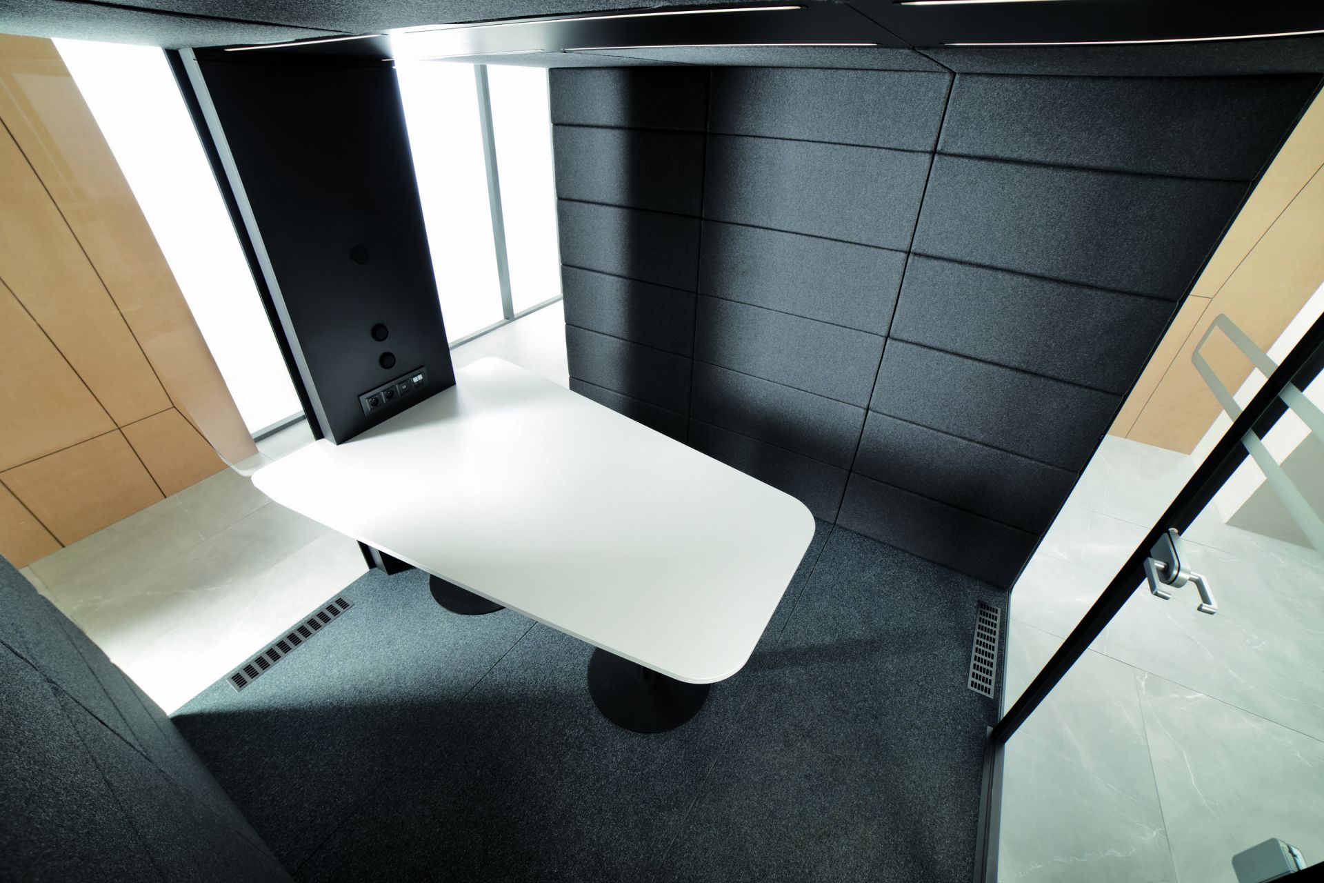 Innenansicht der HushMeet L Meetingbox: Moderner Besprechungsraum mit weißem Tisch und grauen Akustikwänden.