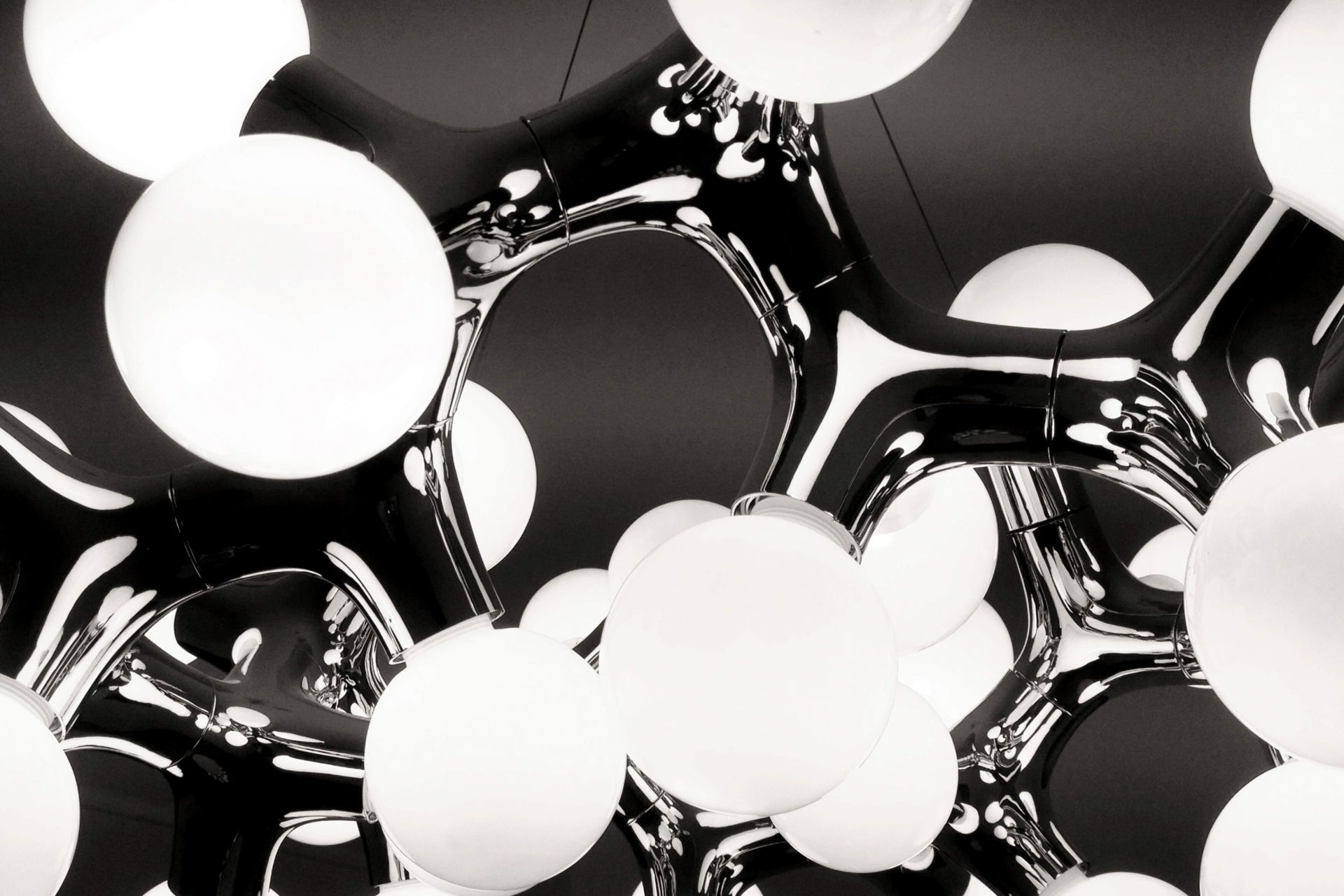 Detailaufnahme der DNA Pendelleuchte in Schwarz mit runden, weißen Lampenschirmen. Moderne Deckenleuchte für Wohnräume.