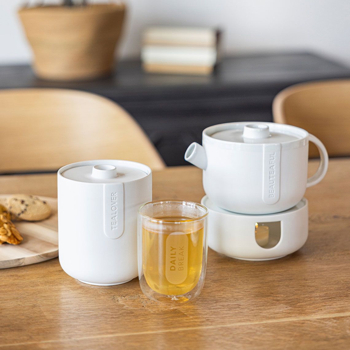 Cozy Time Stövchen und Teekanne klein von Räder, mit Teeglas und Gebäck.