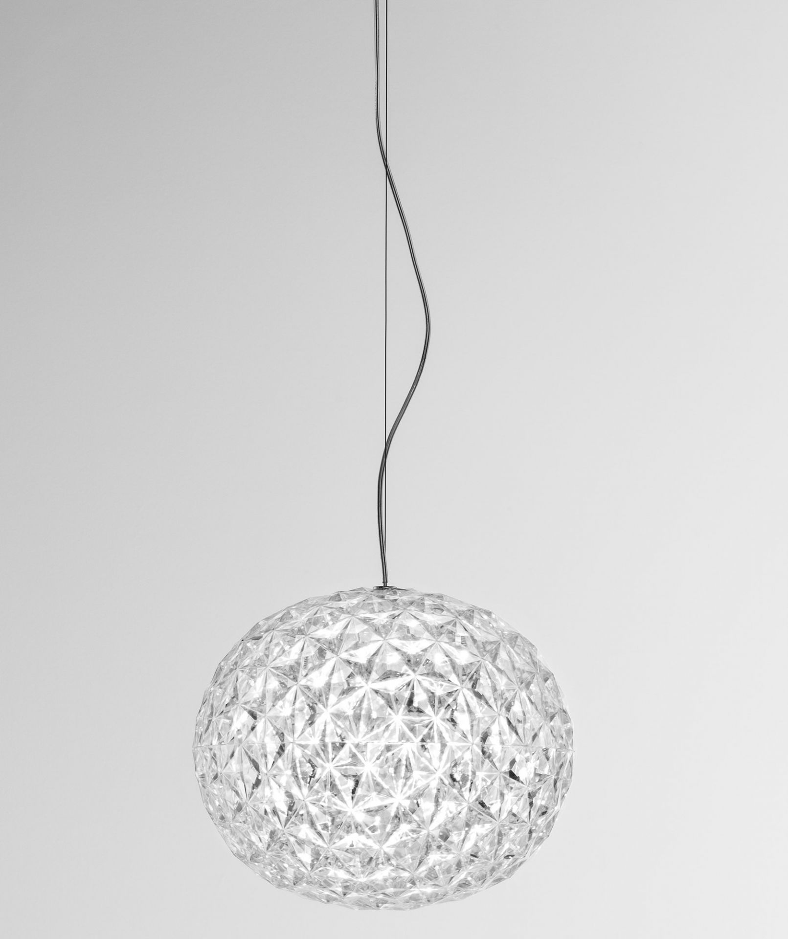 Planet Pendelleuchte von Kartell: Transparente, kugelförmige Designlampe mit facettierter Oberfläche und filigraner Aufhängung.